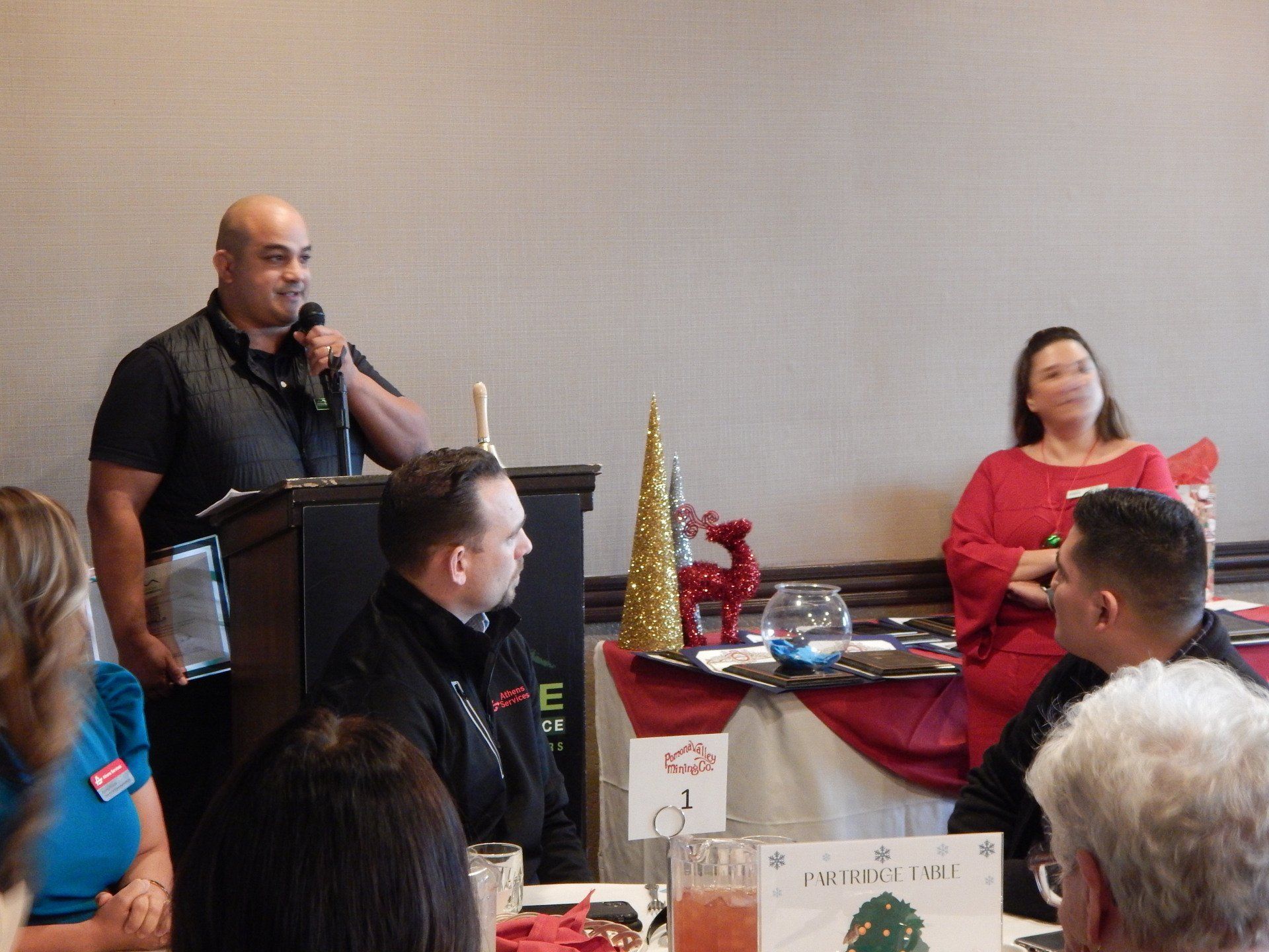 A man is standing at a podium giving a speech to a group of people.