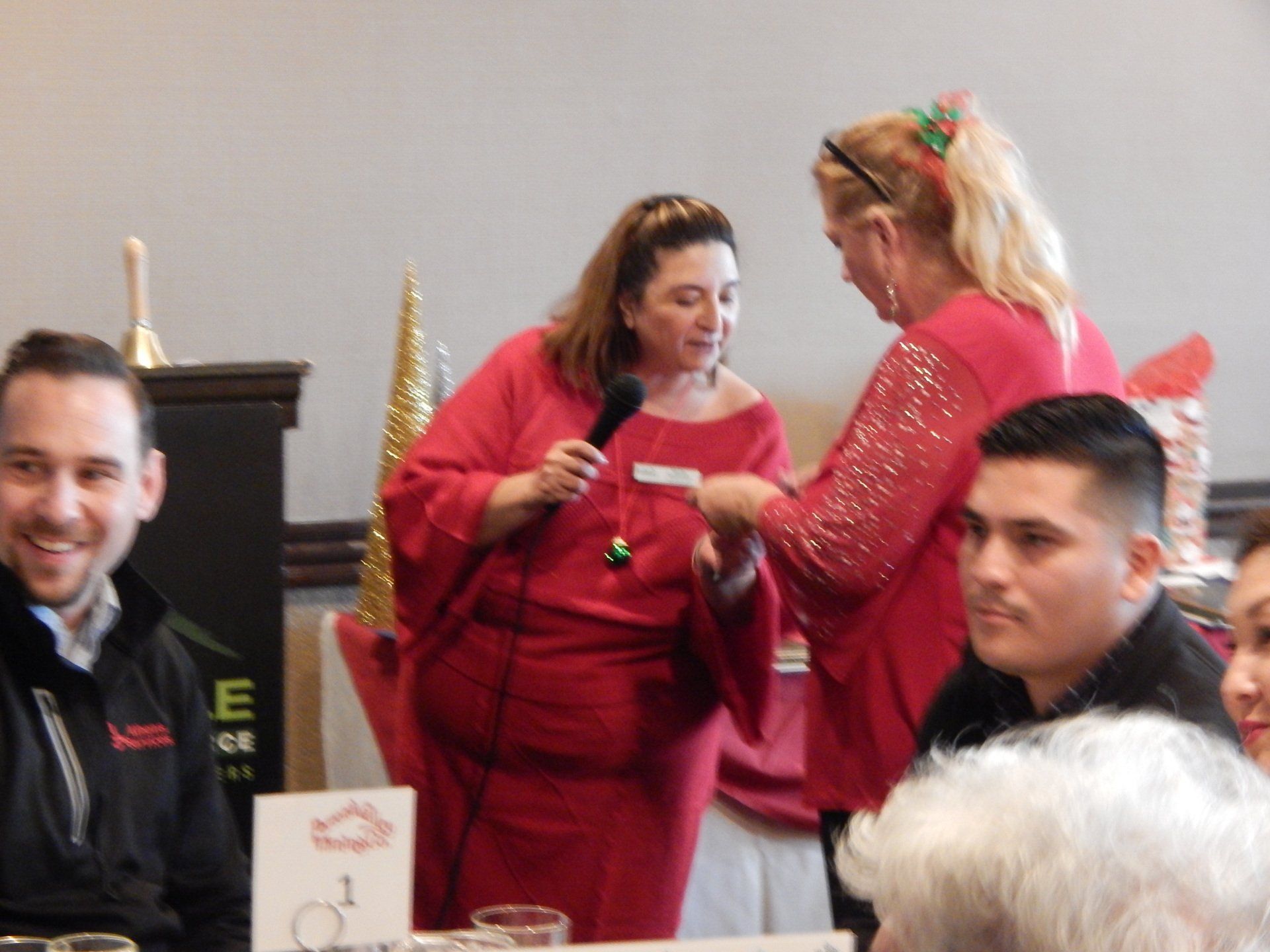 A group of people sitting around a table with a sign that says e on it