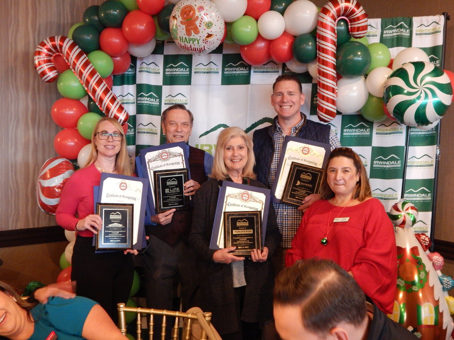A group of people are posing for a picture while holding awards.