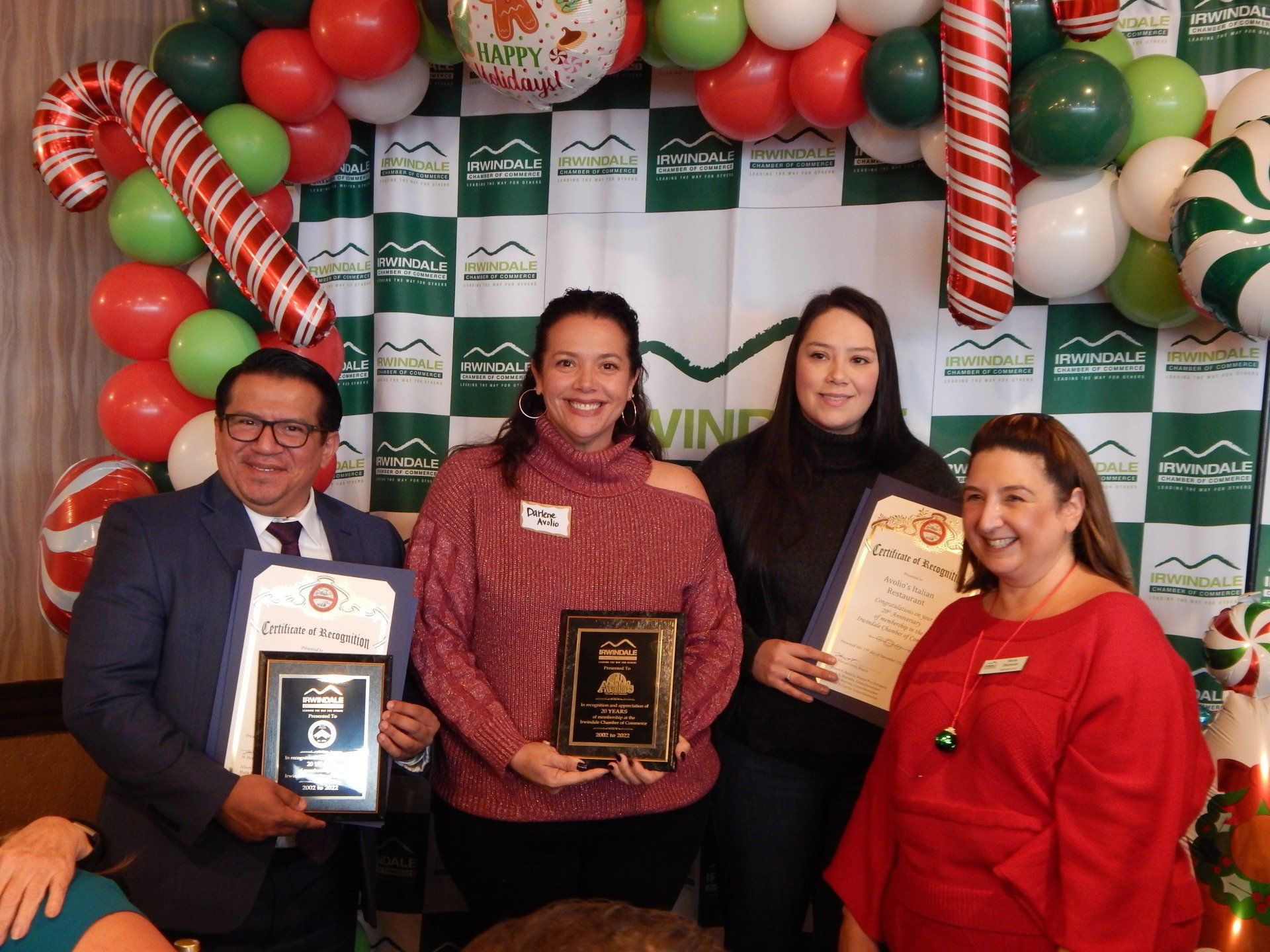 A group of people are posing for a picture with balloons in the background.
