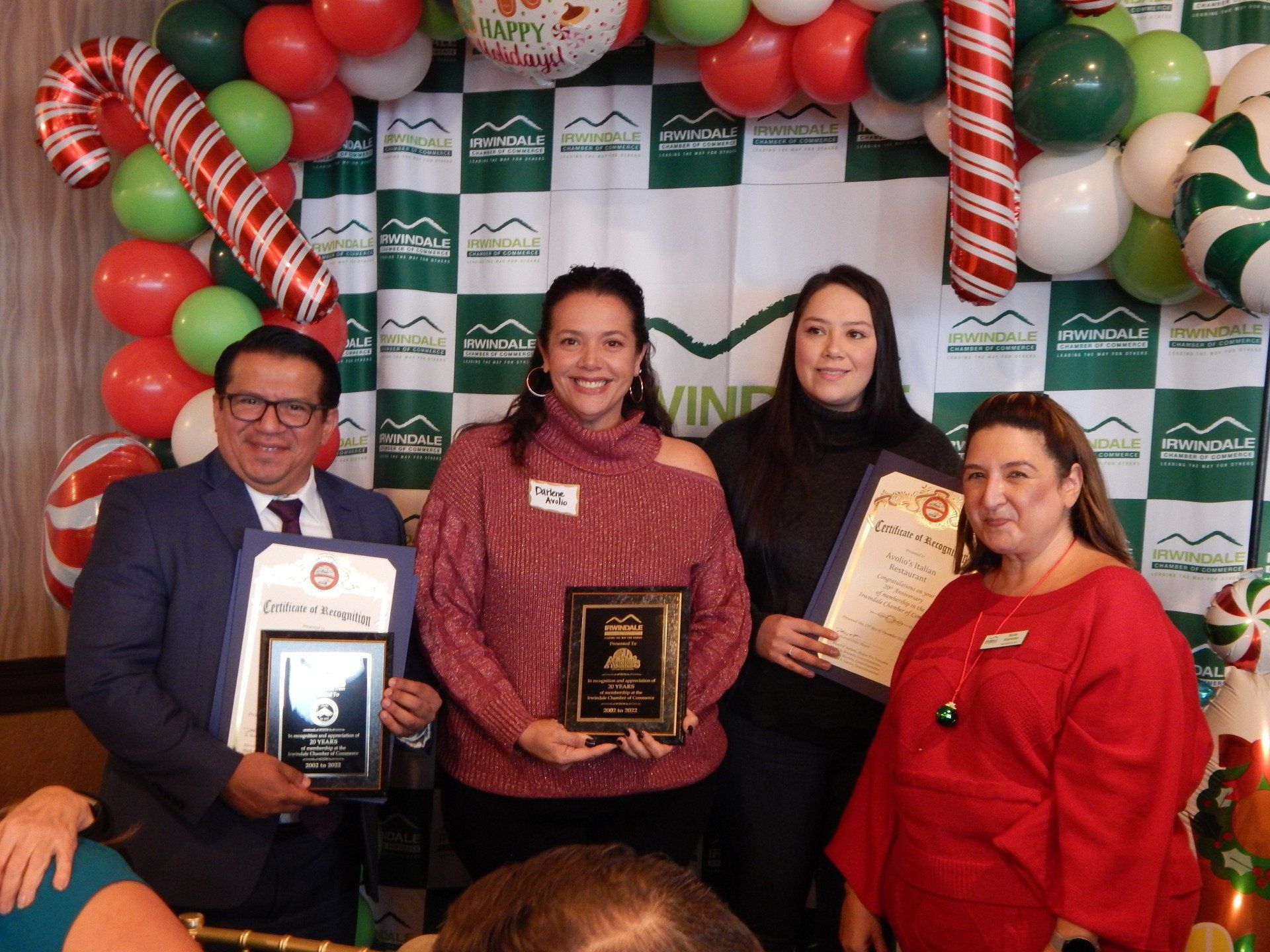 A group of people standing next to each other holding awards.