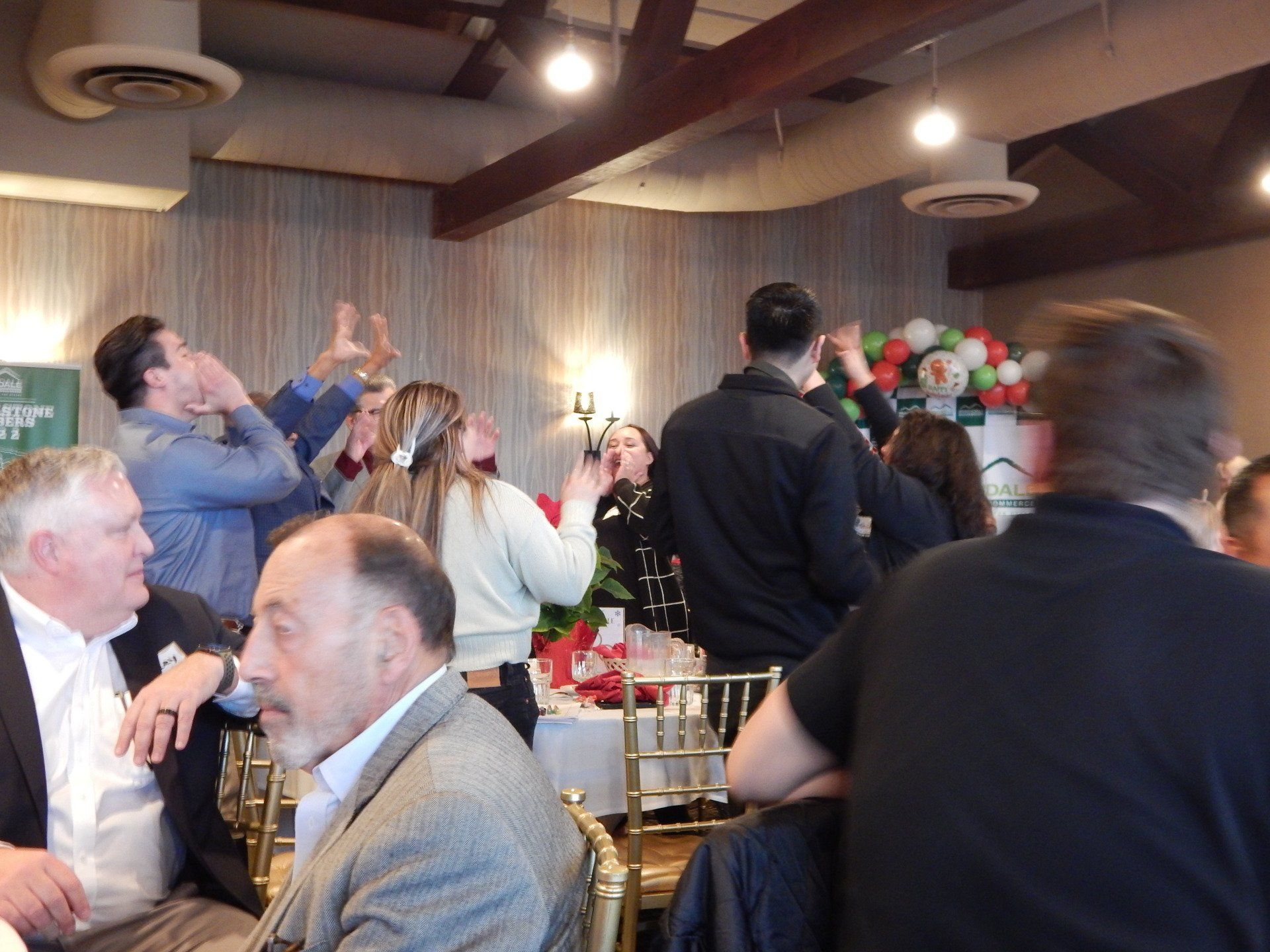 A group of people are gathered in a room with a sign that says ' a ' on it