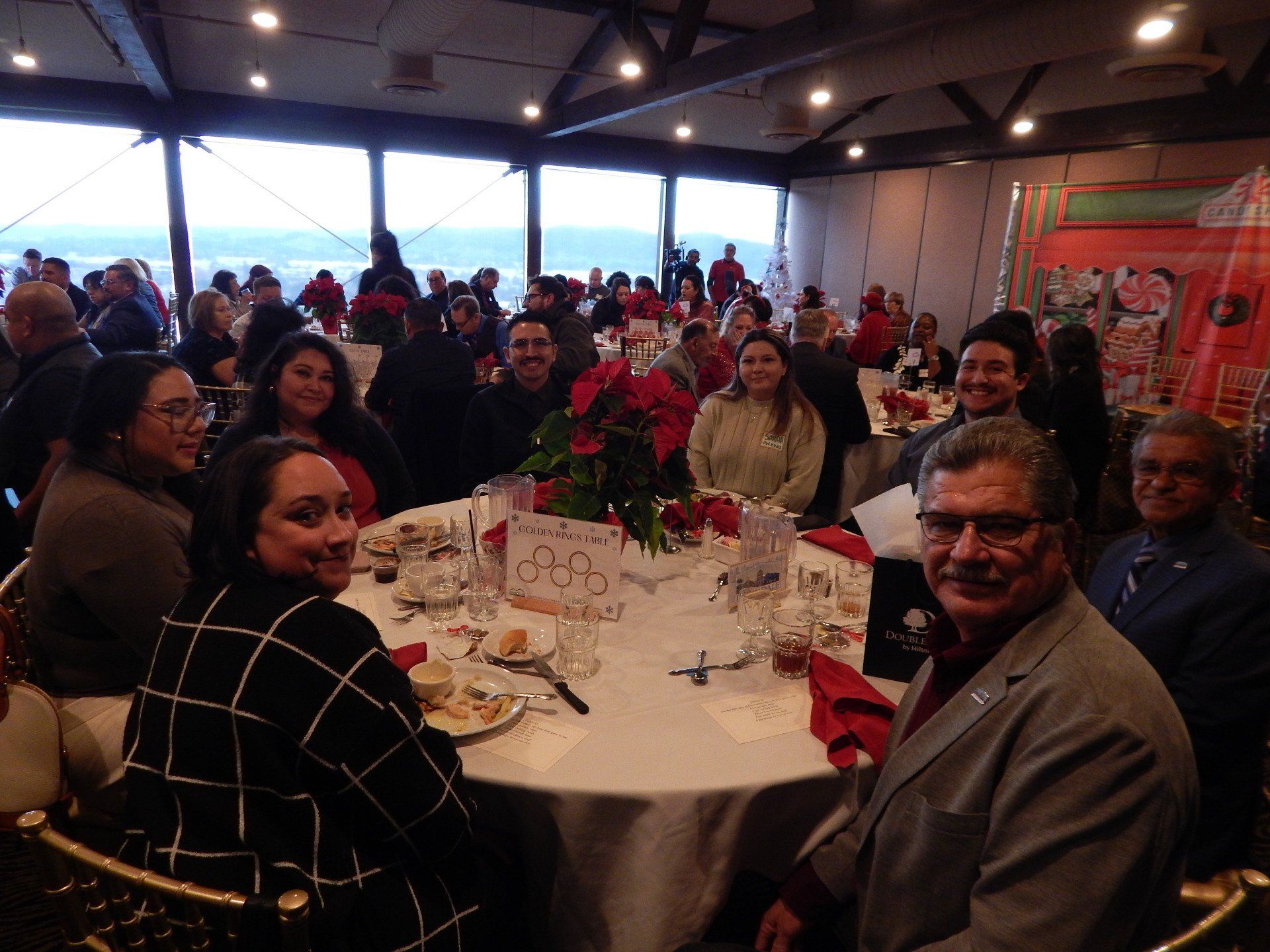 A group of people are sitting at tables in a large room.