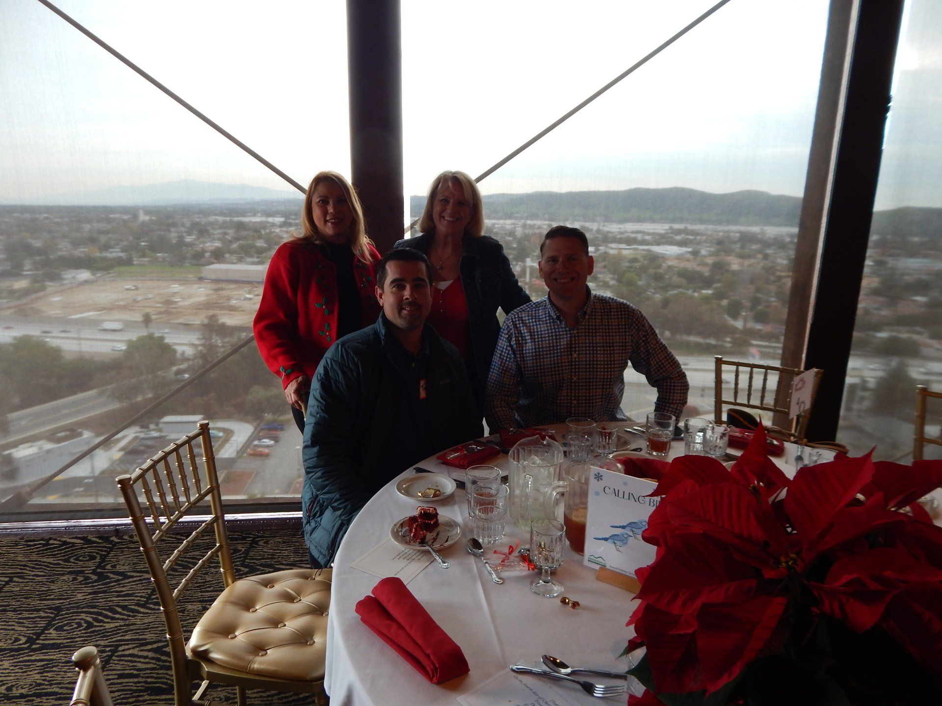 A group of people sitting at a table with a view of a city