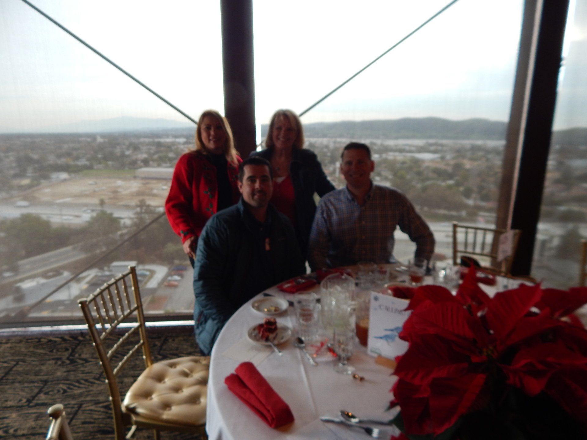 A group of people sitting at a table with a view of a city