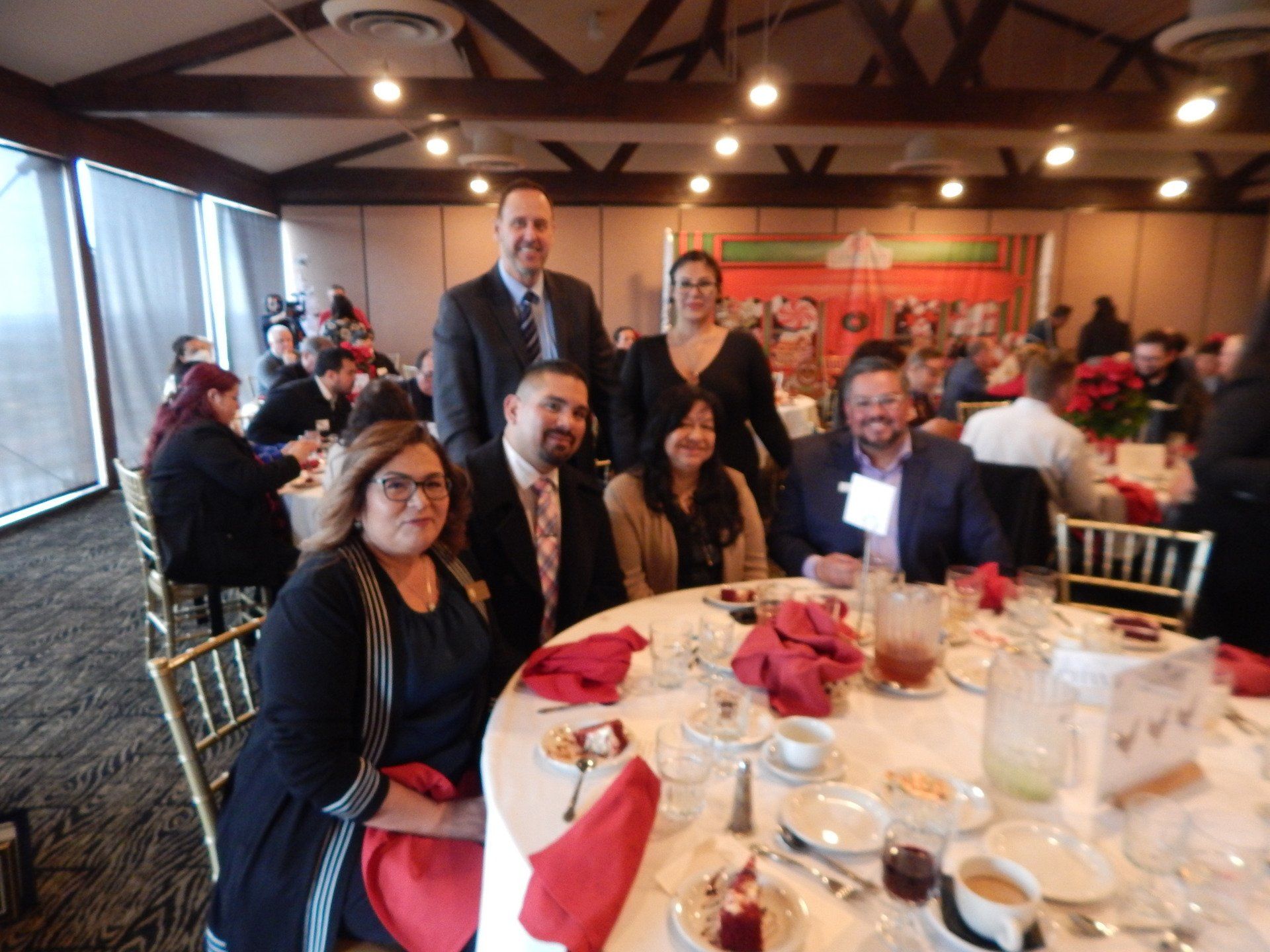 A group of people sitting at a table with red napkins