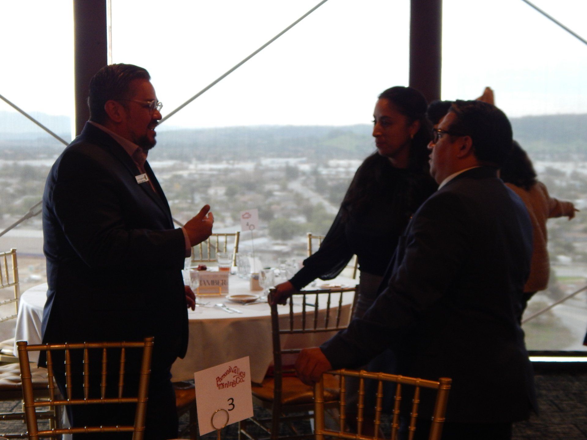 A group of people standing around a table with a number 3 on it