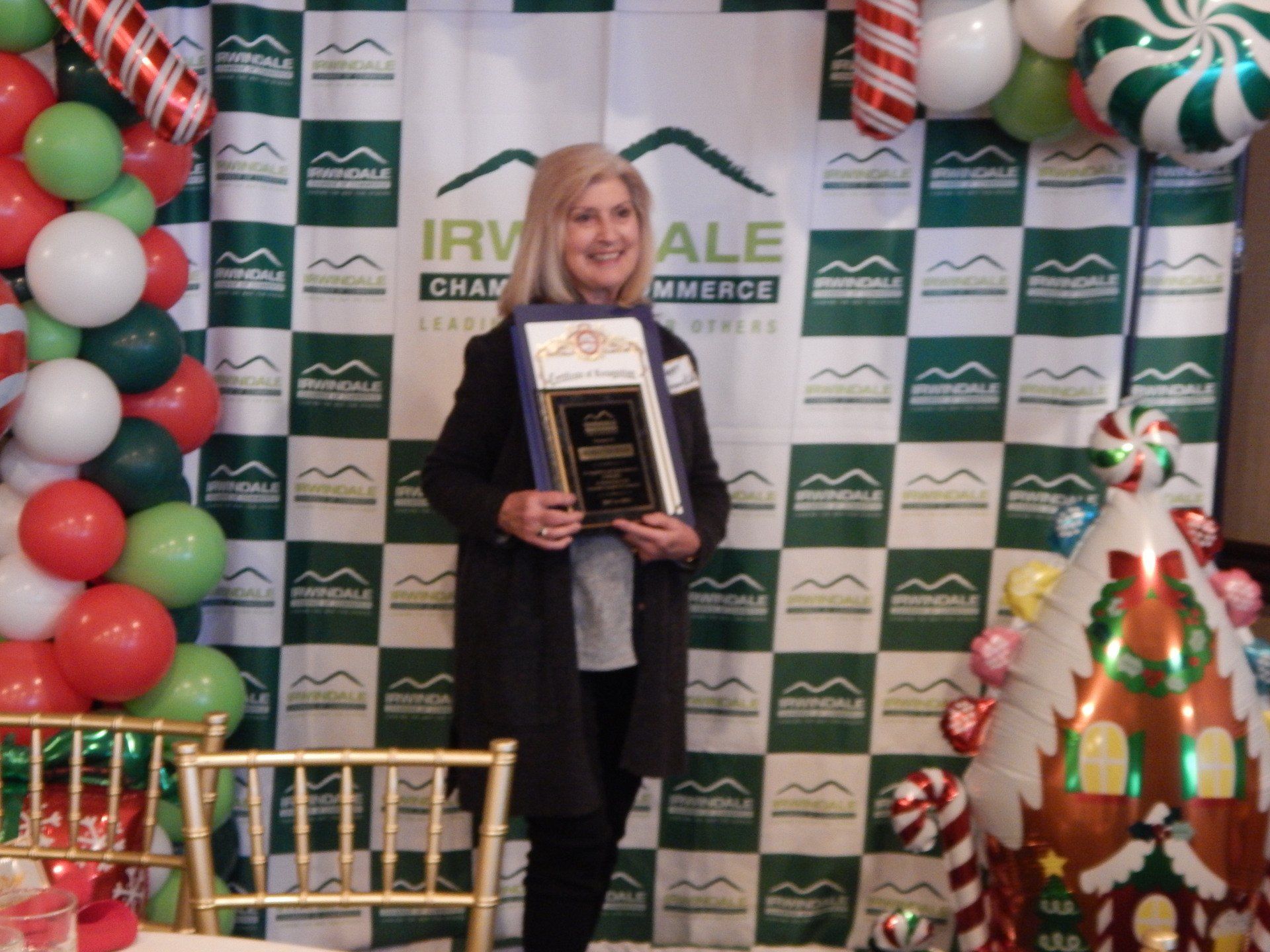 A woman stands in front of a backdrop that says irv ale