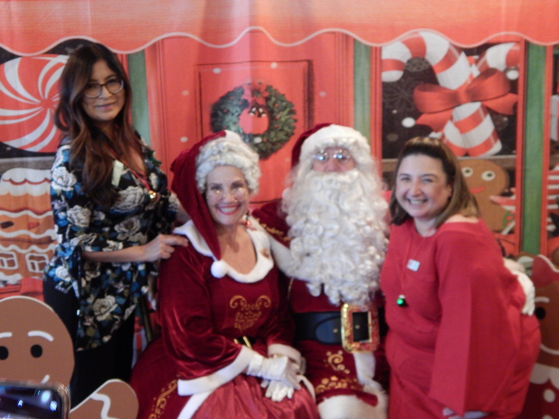 Three women are posing for a picture with santa claus
