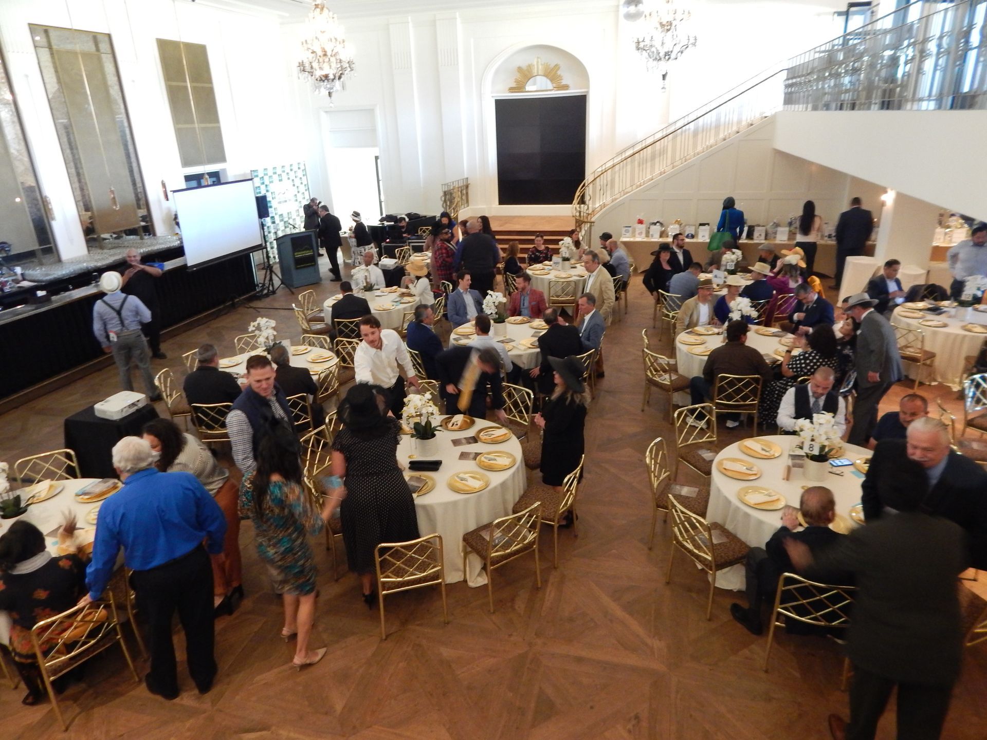 A group of people are sitting at tables in a large room.