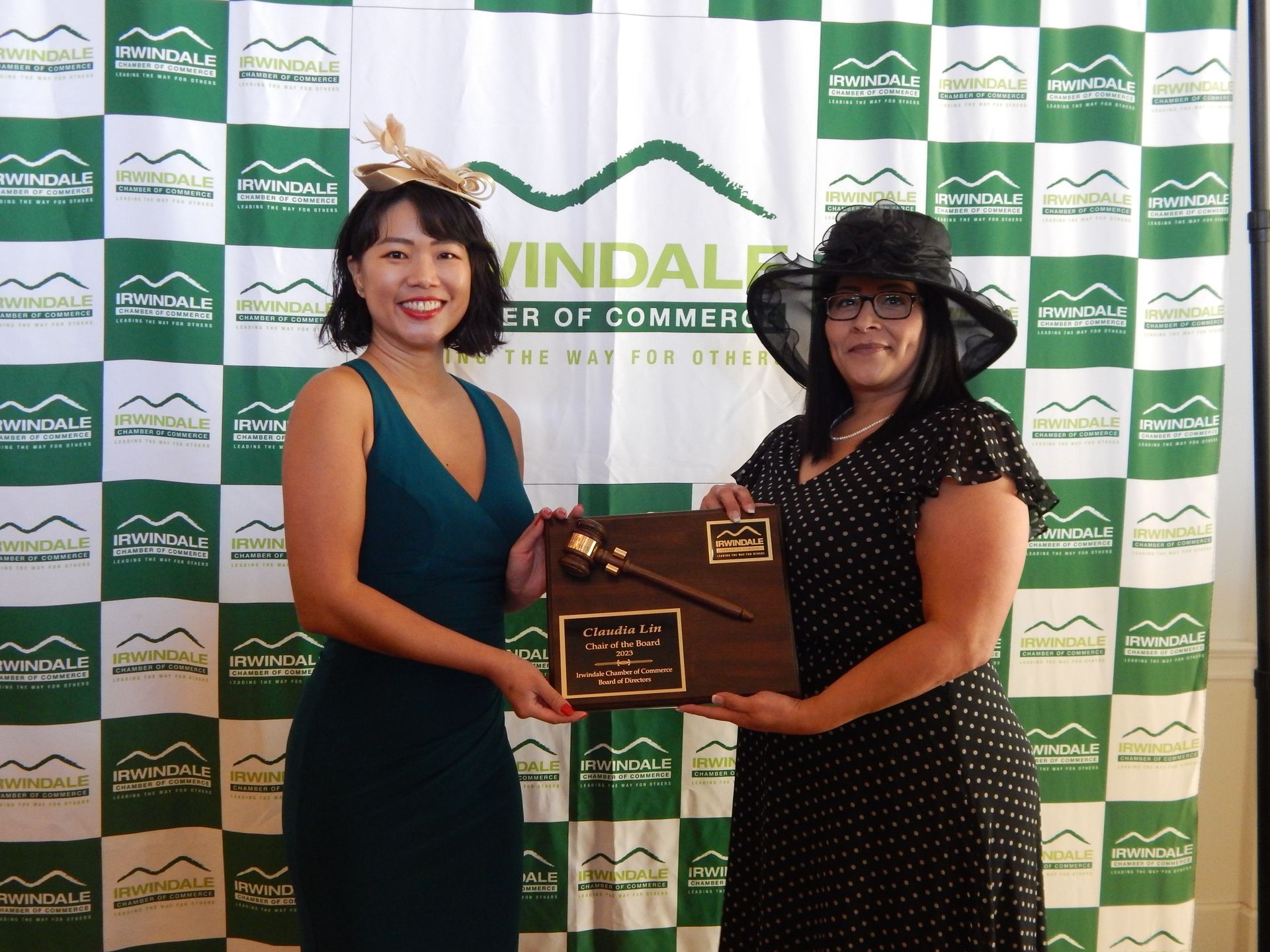 Two women standing in front of a green and white checkered backdrop