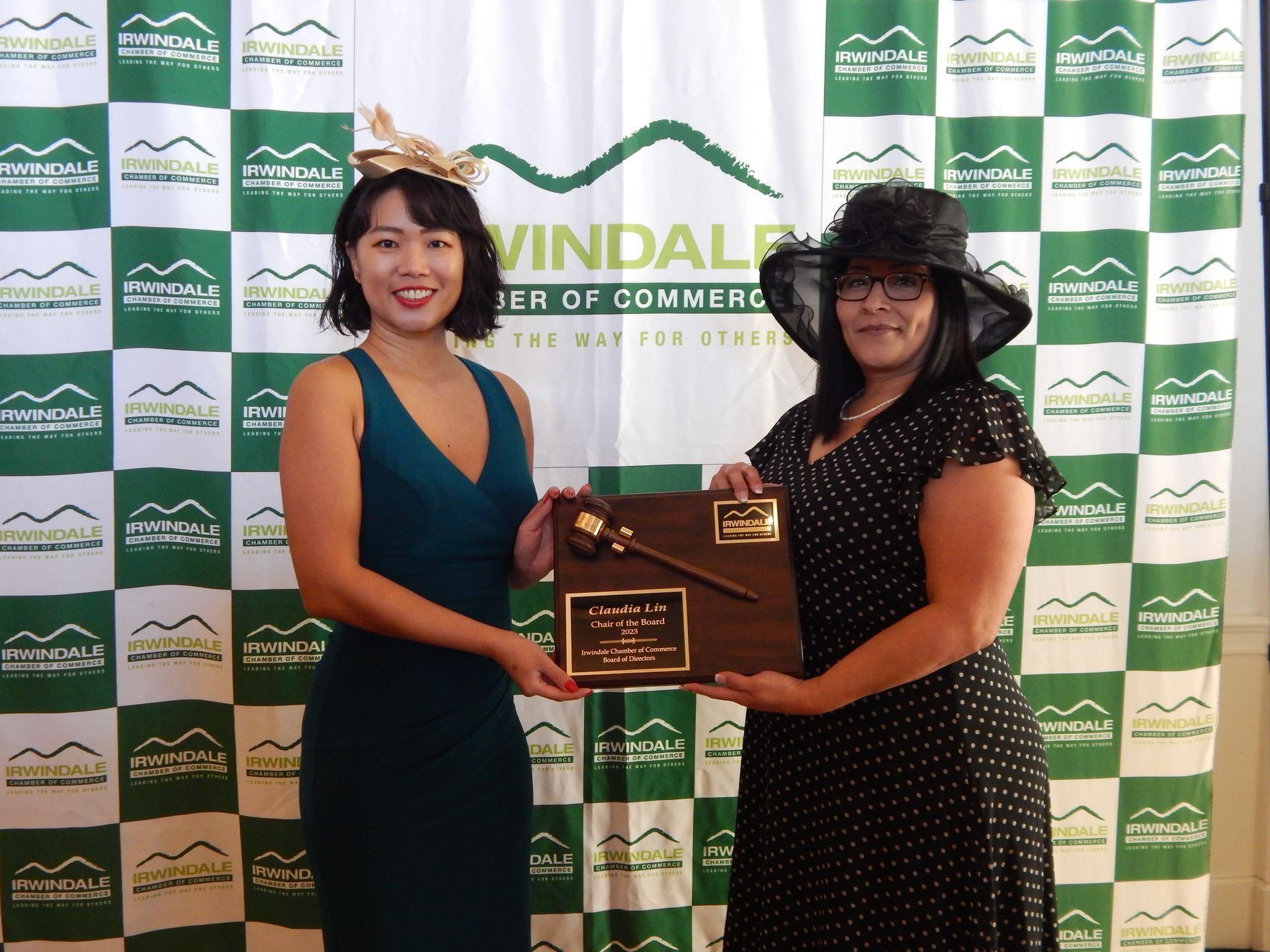 Two women standing in front of a wall that says windale