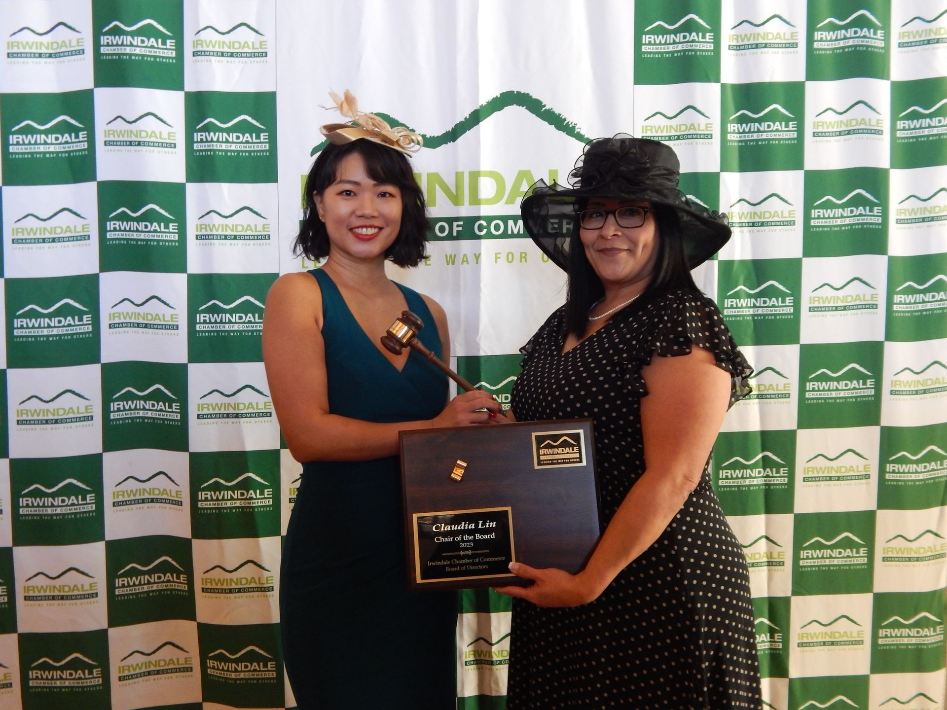 Two women standing in front of a green and white checkered backdrop
