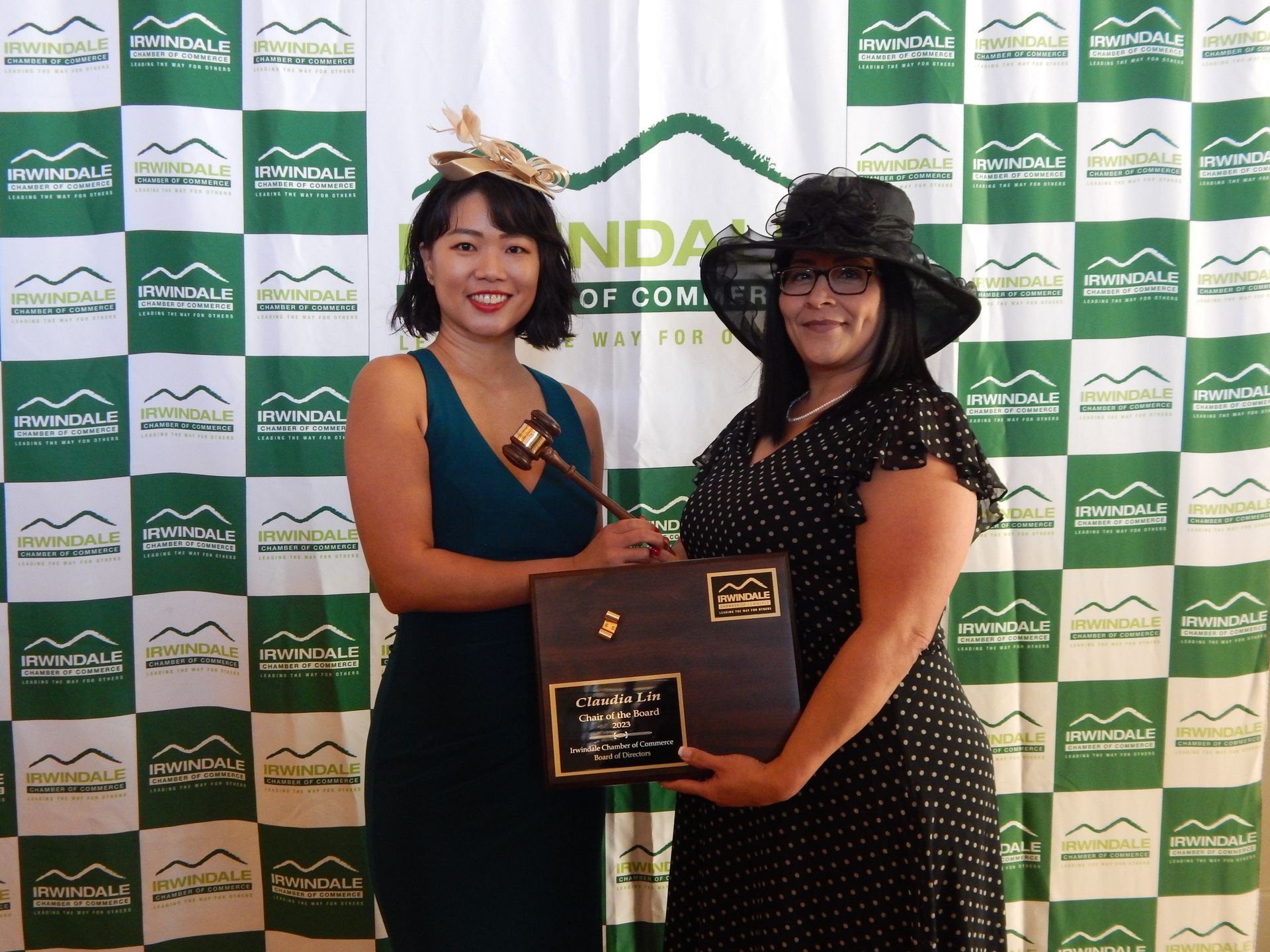 Two women are posing for a picture in front of a wall that says nda