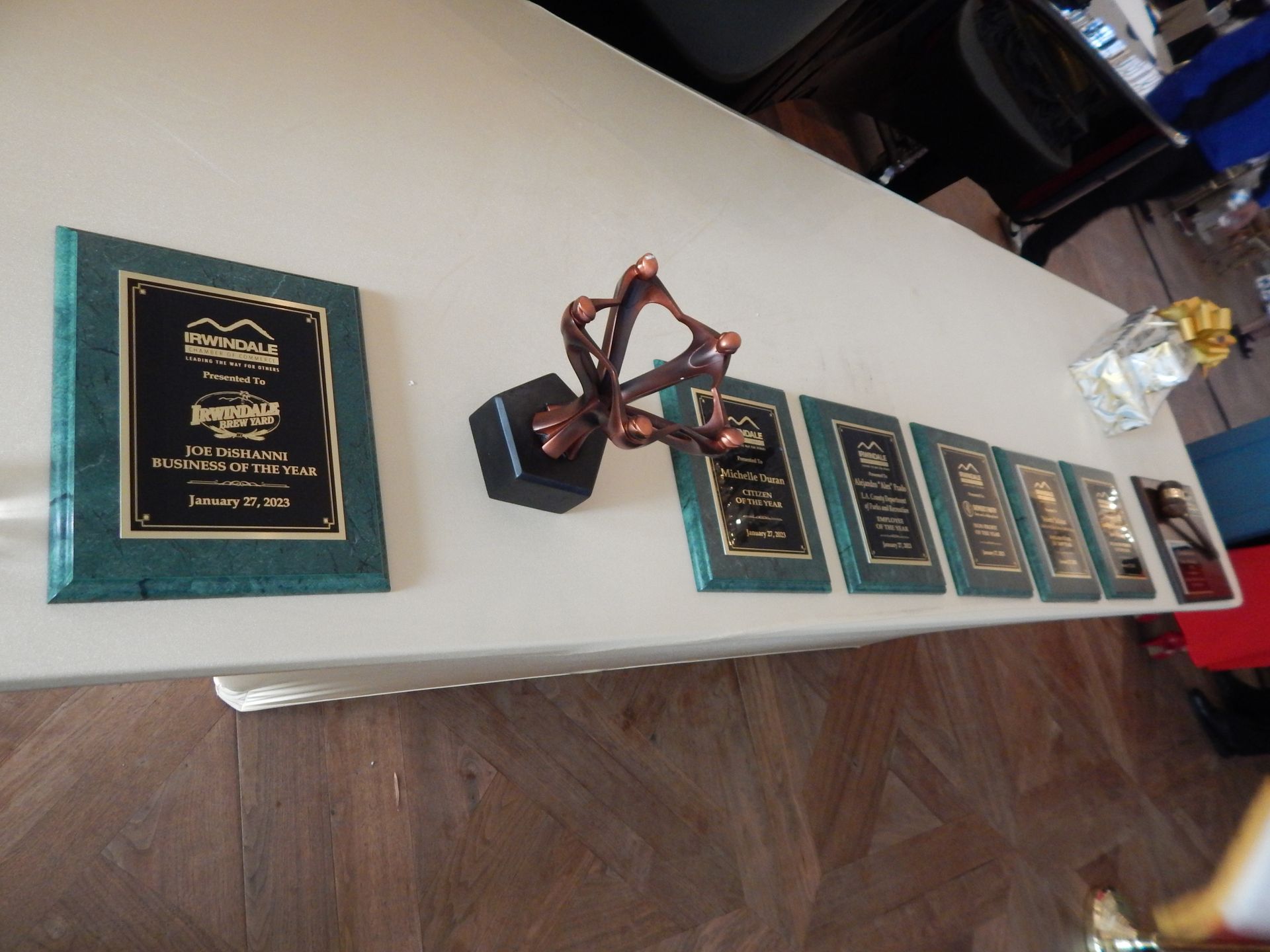 A row of plaques and a trophy on a table