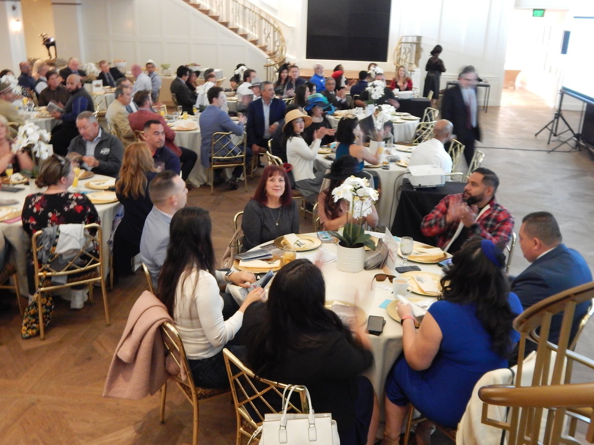 A large group of people are sitting at tables in a room.