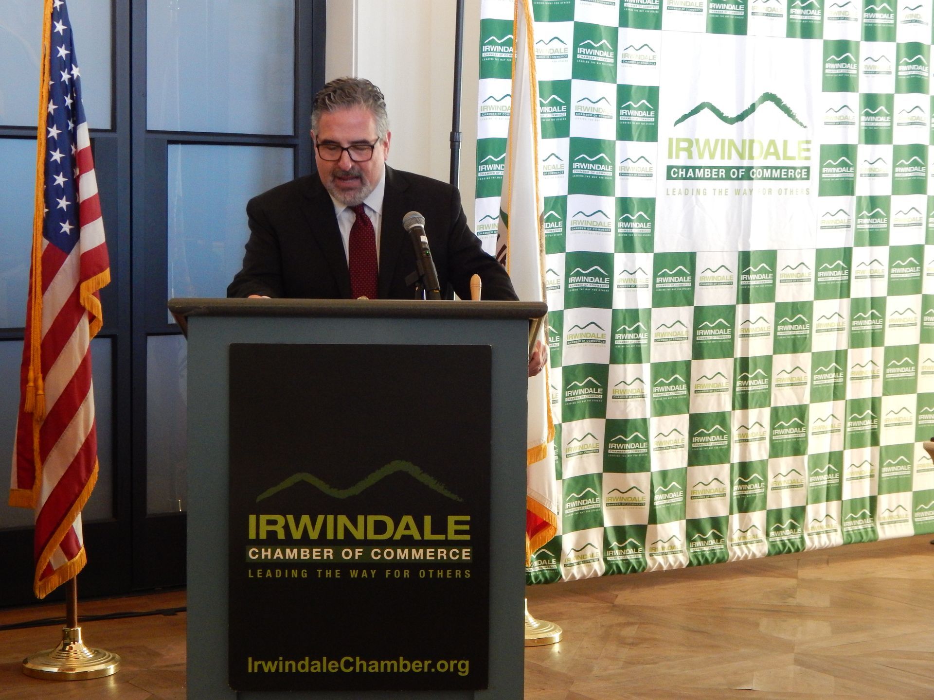 A man stands behind a podium that says irwindale chamber of commerce