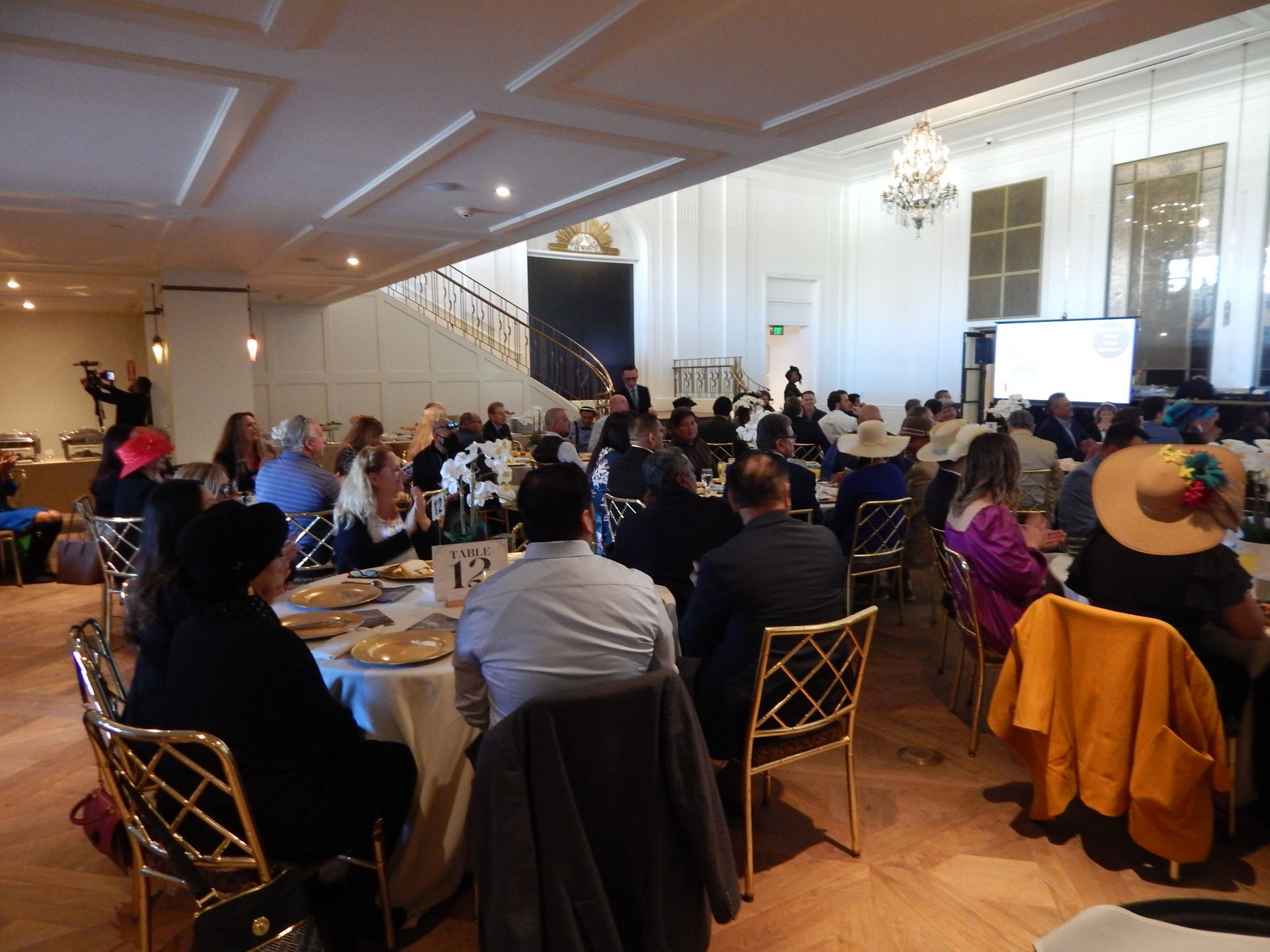 A large group of people are sitting at tables in a large room.