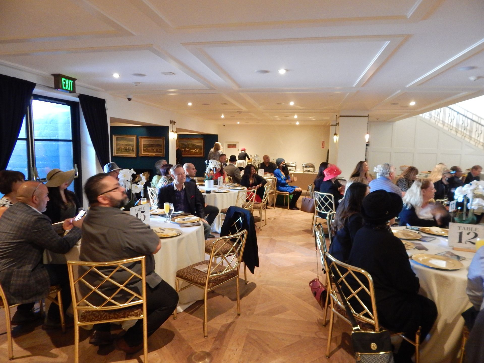 A group of people are sitting at tables in a large room.