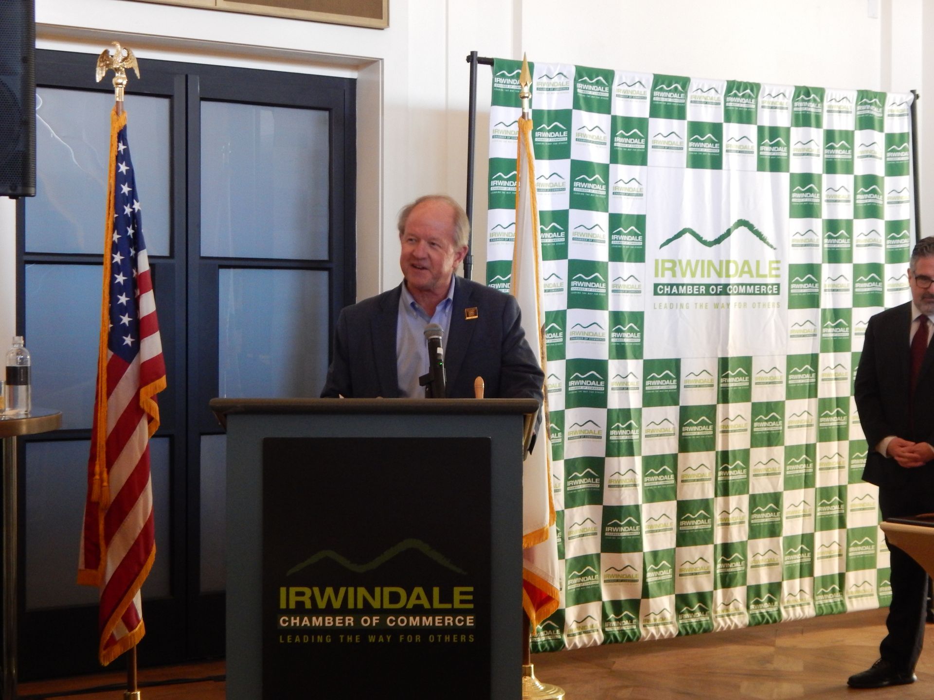 A man stands behind a podium that says irwindale chamber of commerce