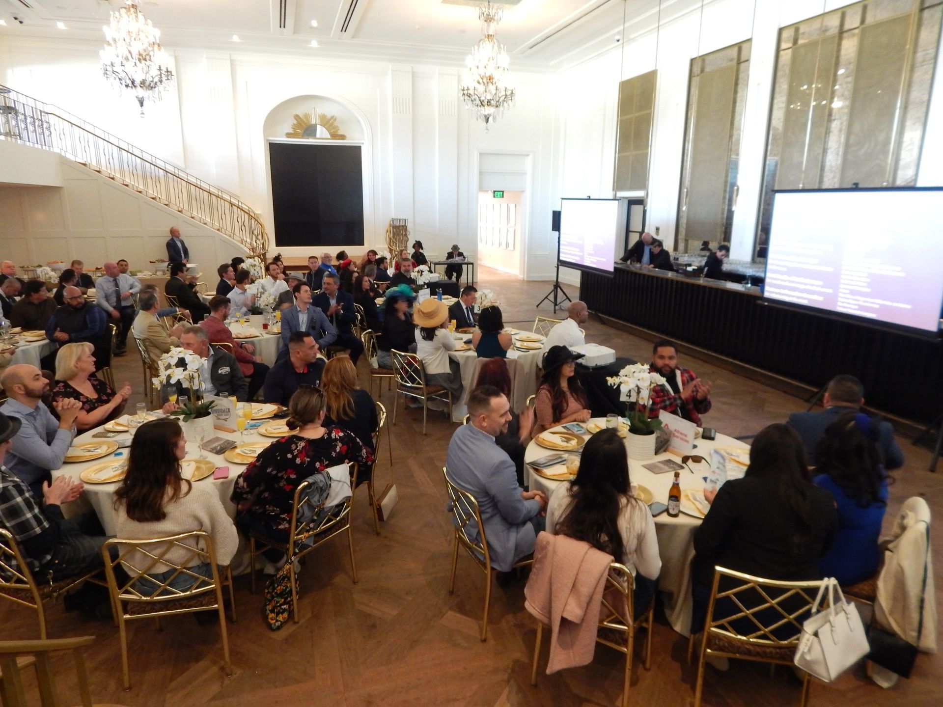 A large group of people are sitting at tables in a large room.