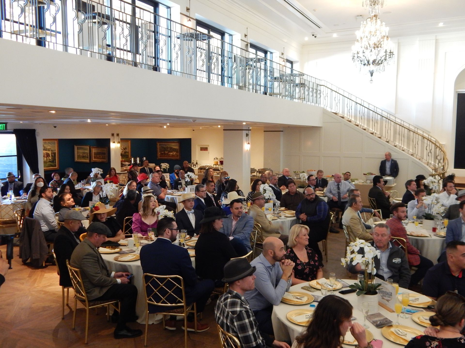A large group of people are sitting at tables in a large room.