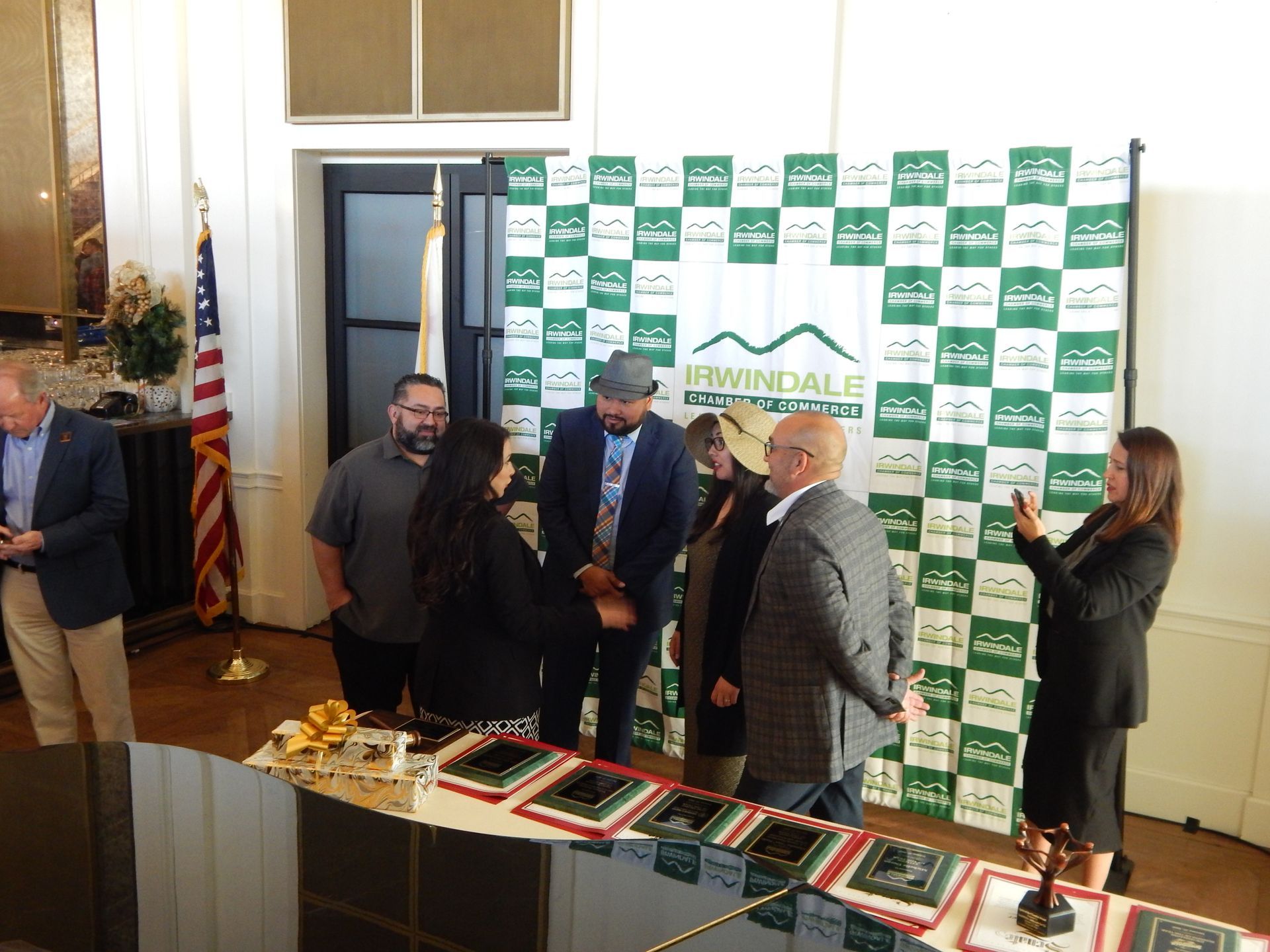 A group of people standing around a table in front of a sign that says winddale