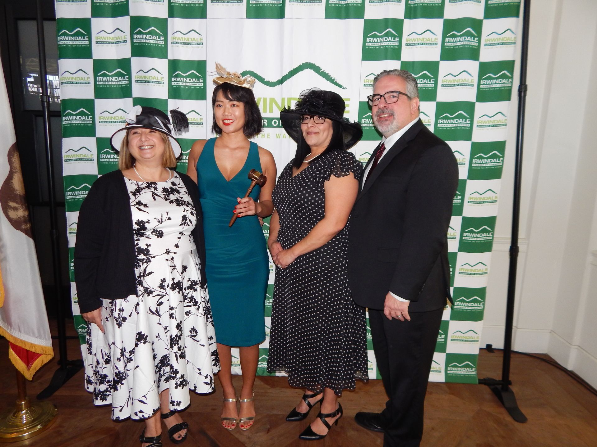 A group of people standing in front of a green and white checkered backdrop