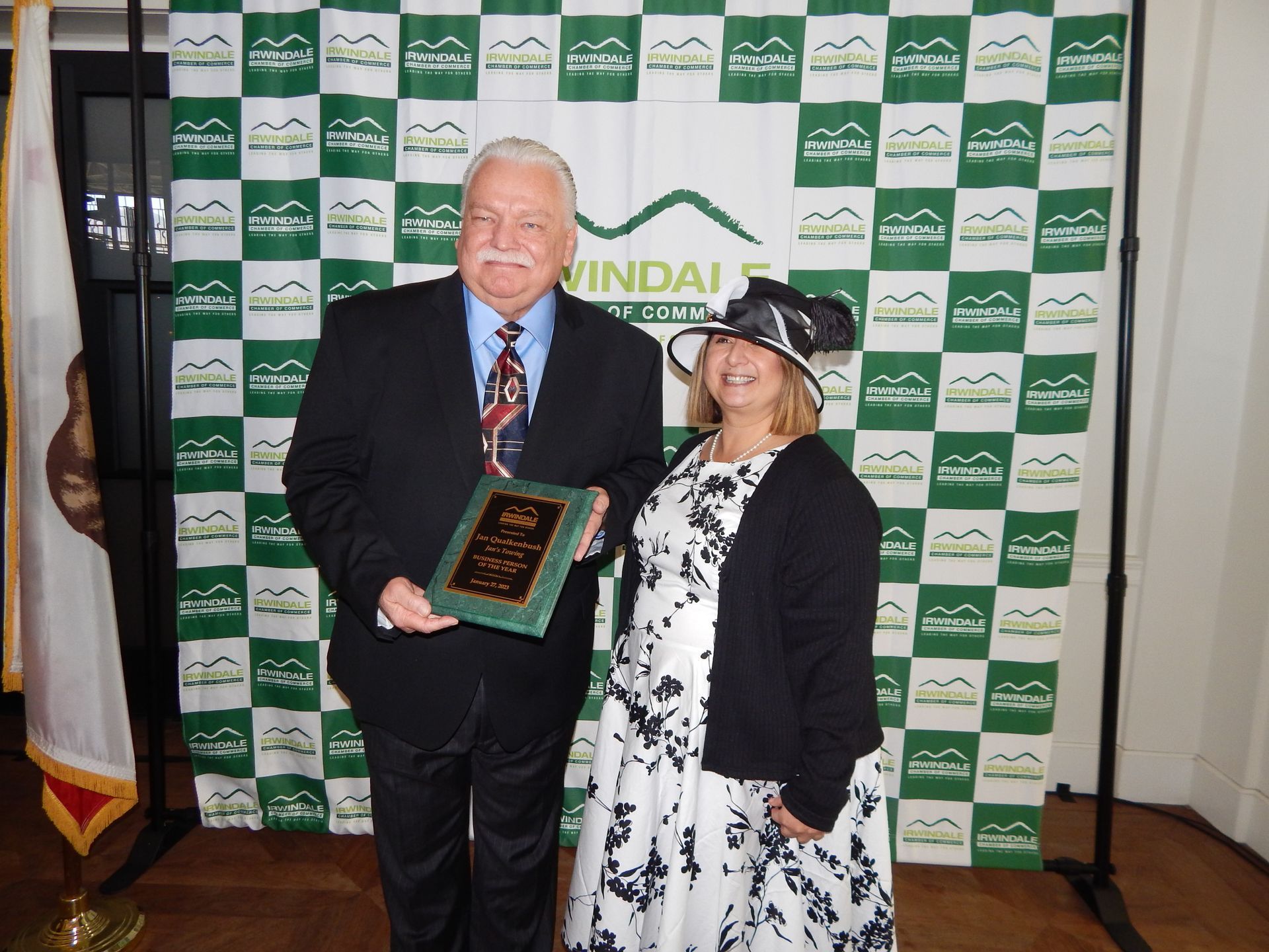 A man and woman standing in front of a wall that says windale