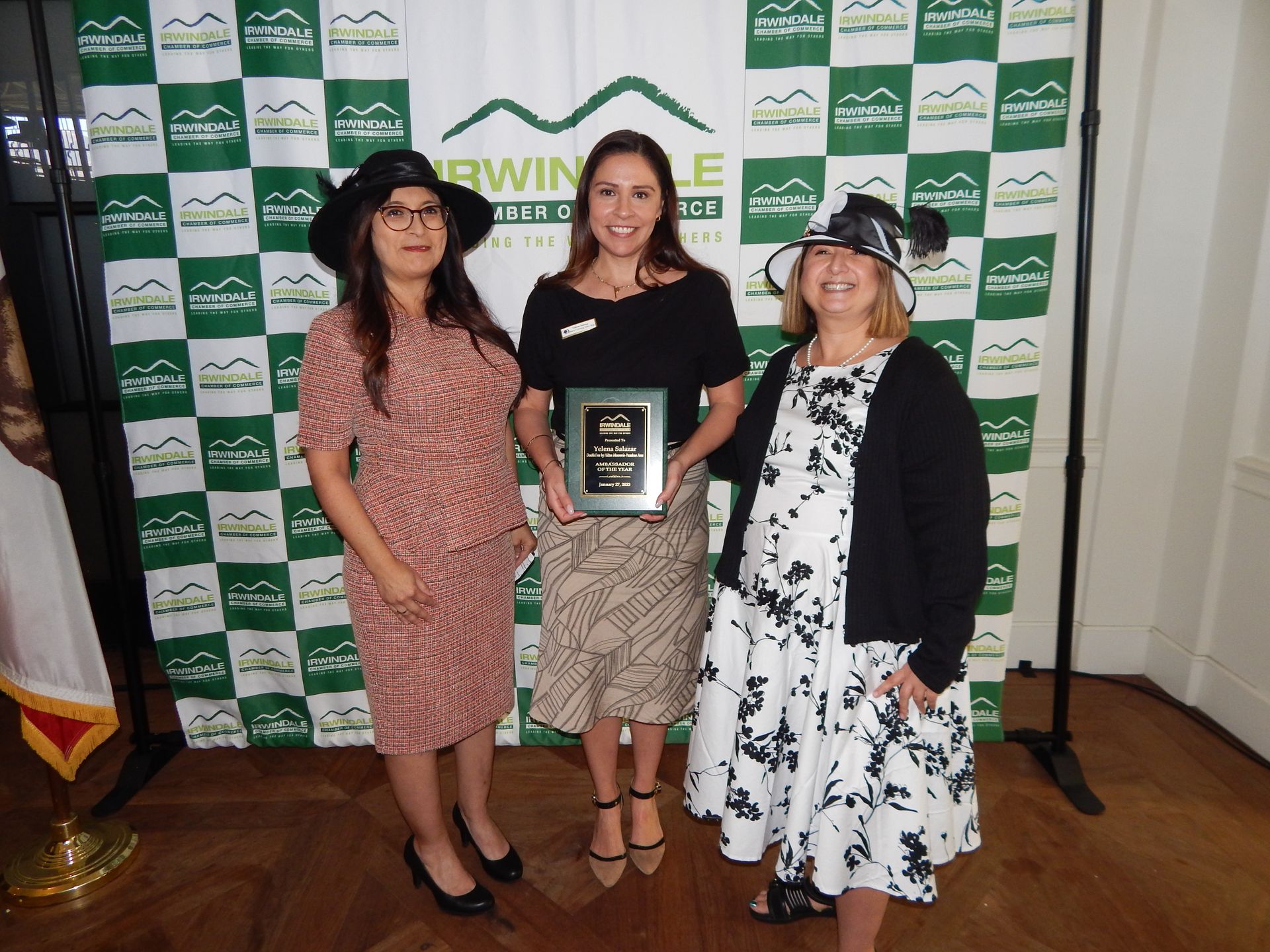 Three women standing in front of a green and white checkered backdrop