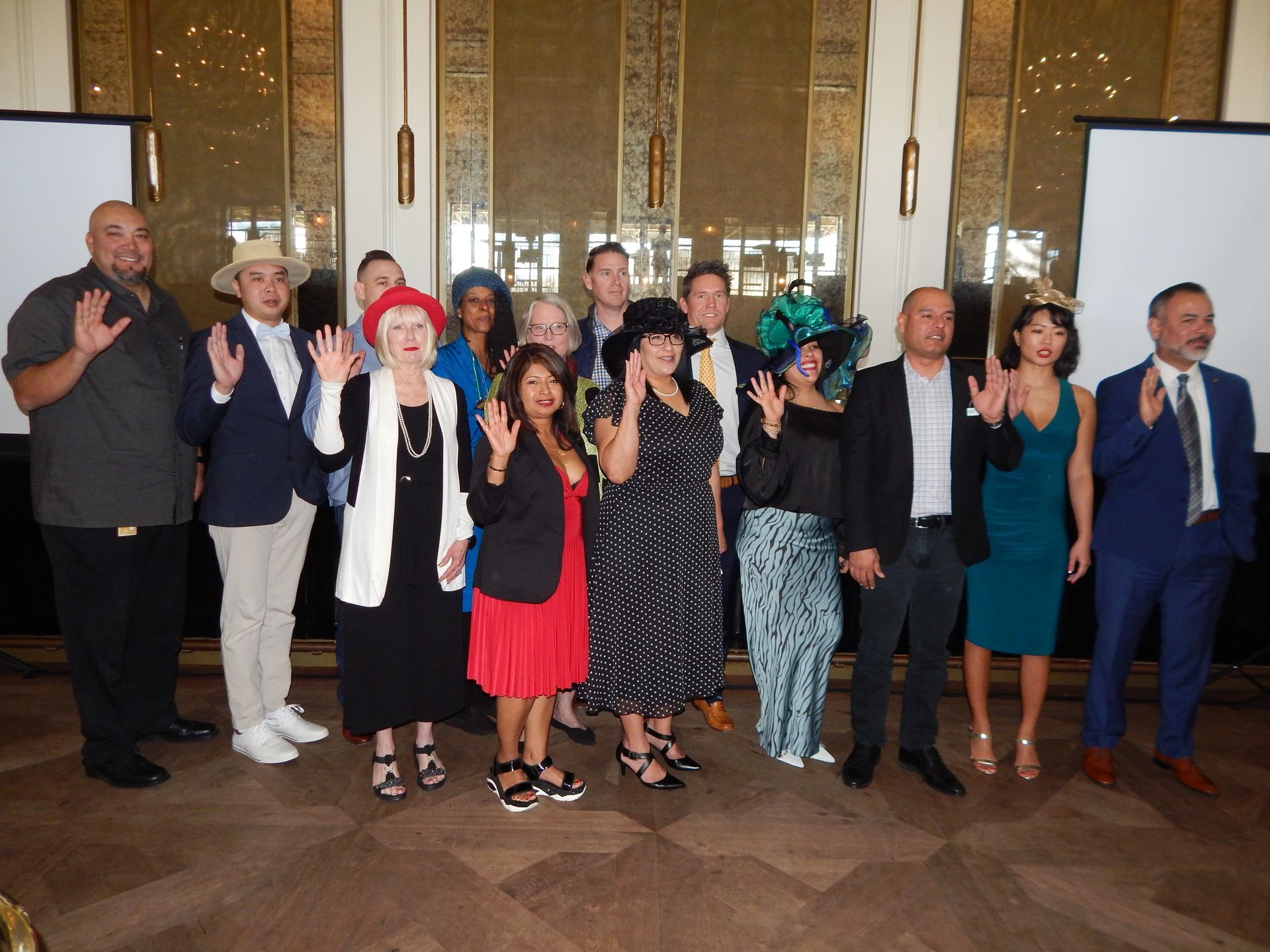 A group of people posing for a picture with their hands up