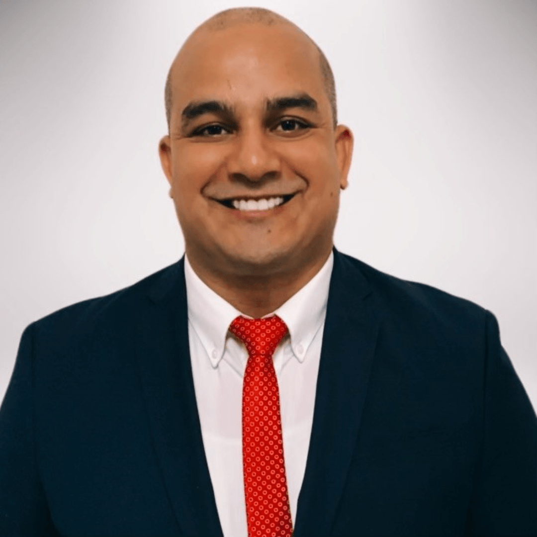 A man in a suit and tie is smiling for the camera