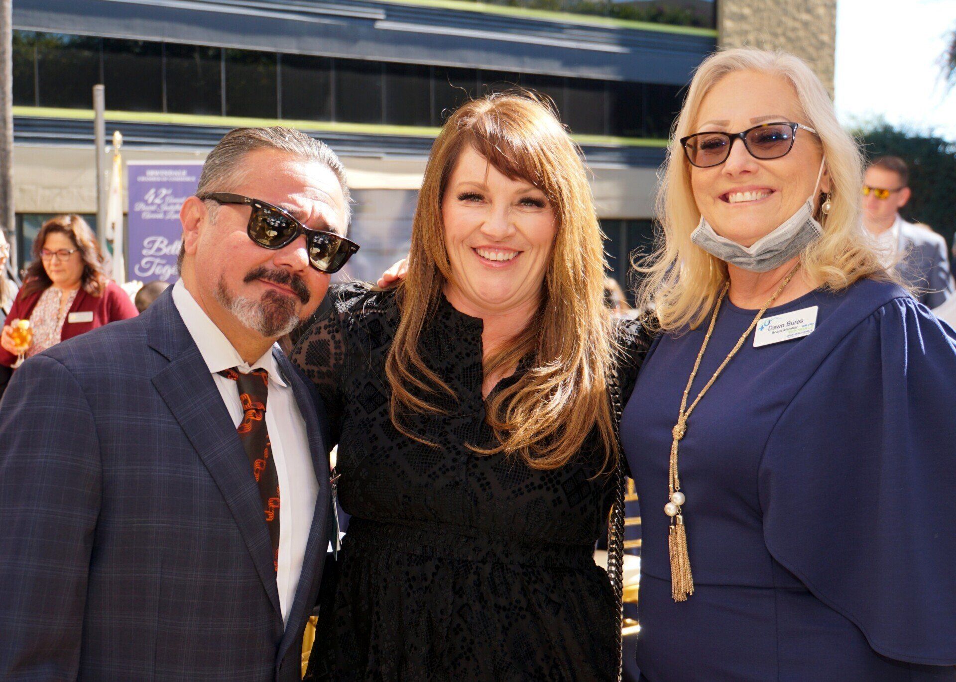 A man and two women are posing for a picture together.