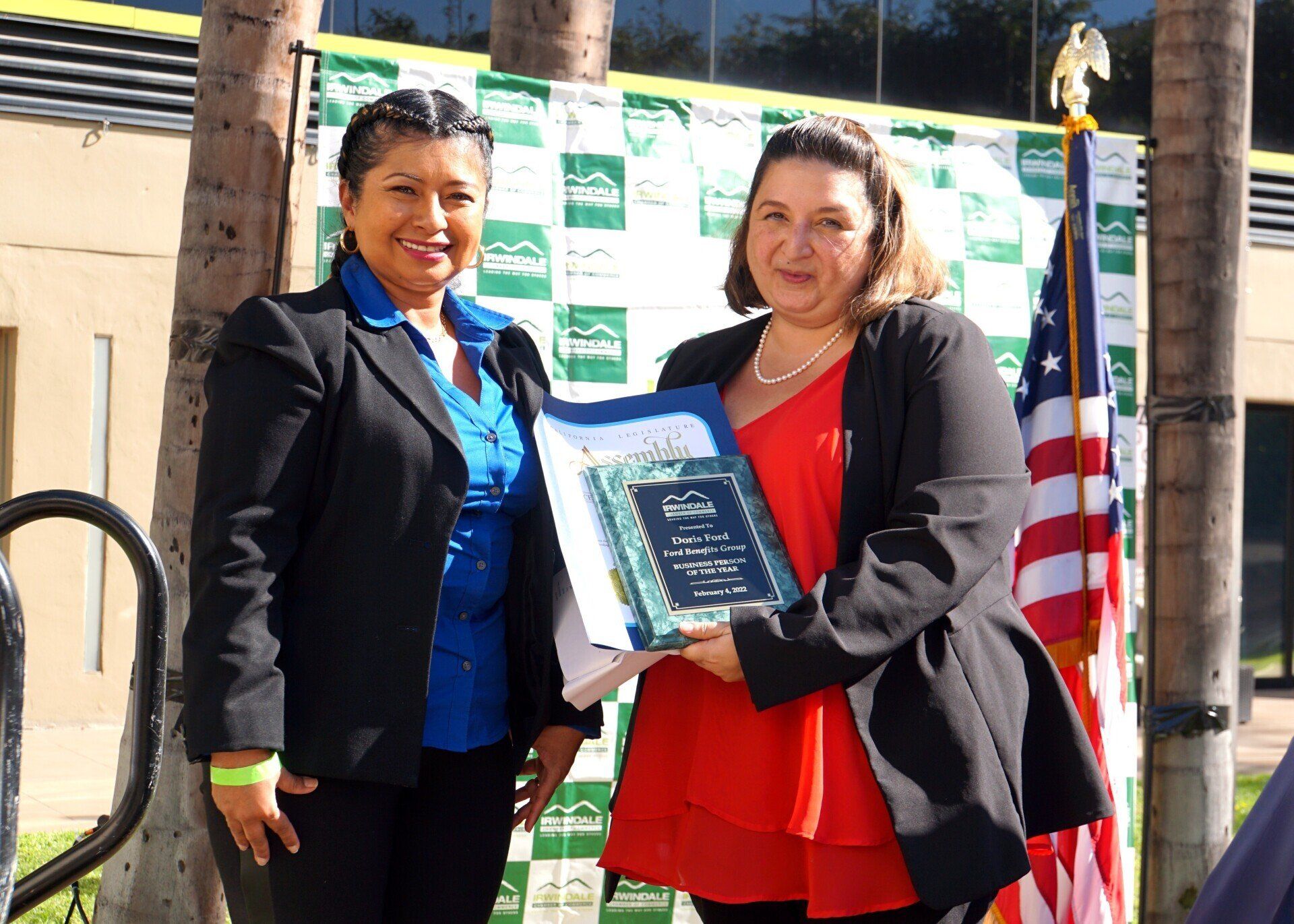 Two women are standing next to each other and one is holding a book