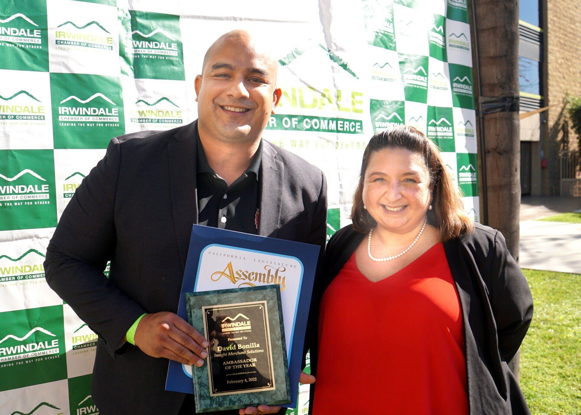 A man and a woman are standing next to each other holding a certificate.