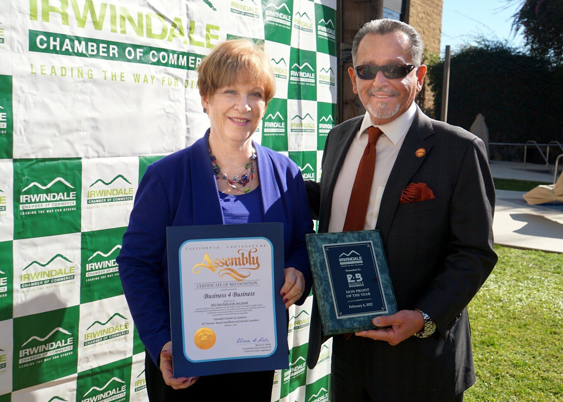 A man and a woman are standing next to each other holding a certificate