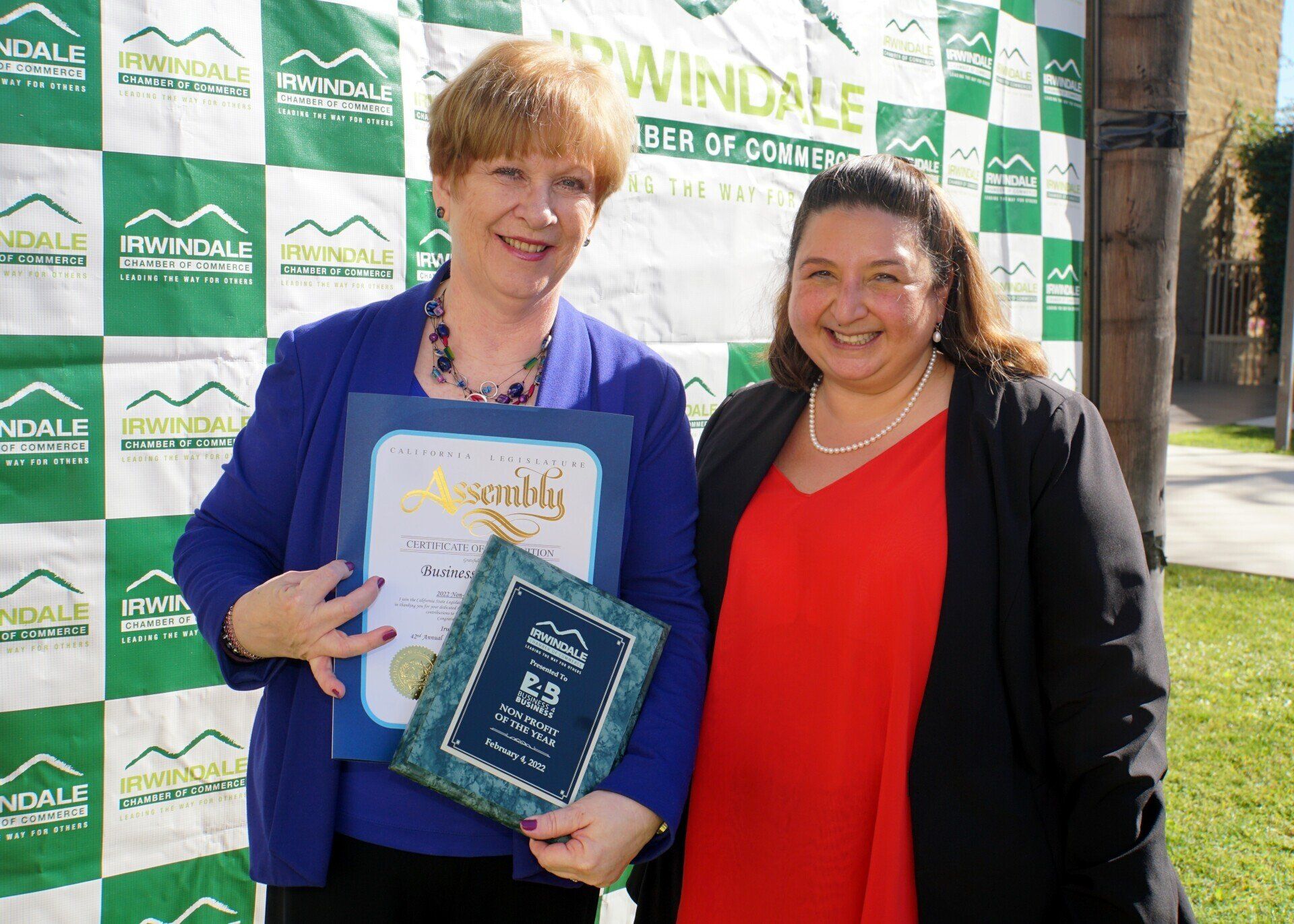 Two women are standing next to each other holding a certificate.