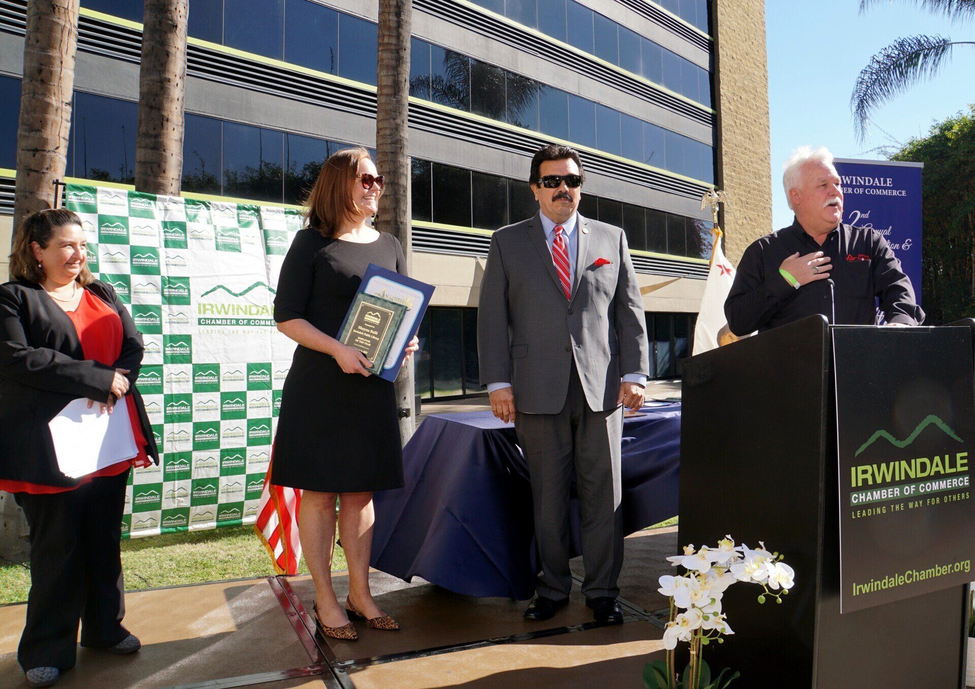 A group of people standing in front of a podium that says iraindale