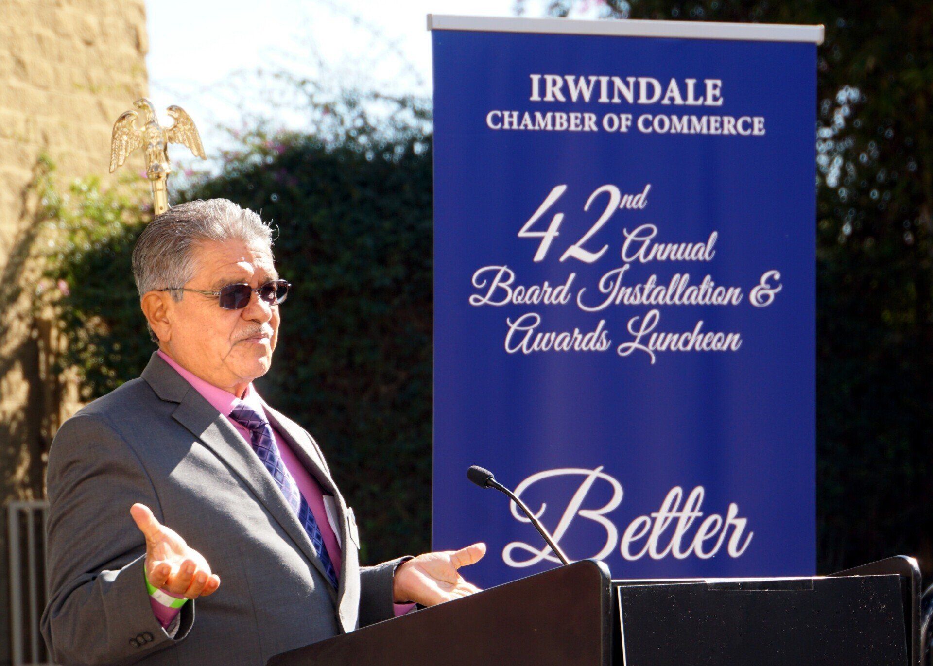 A man stands at a podium in front of a sign that says irwindale chamber of commerce