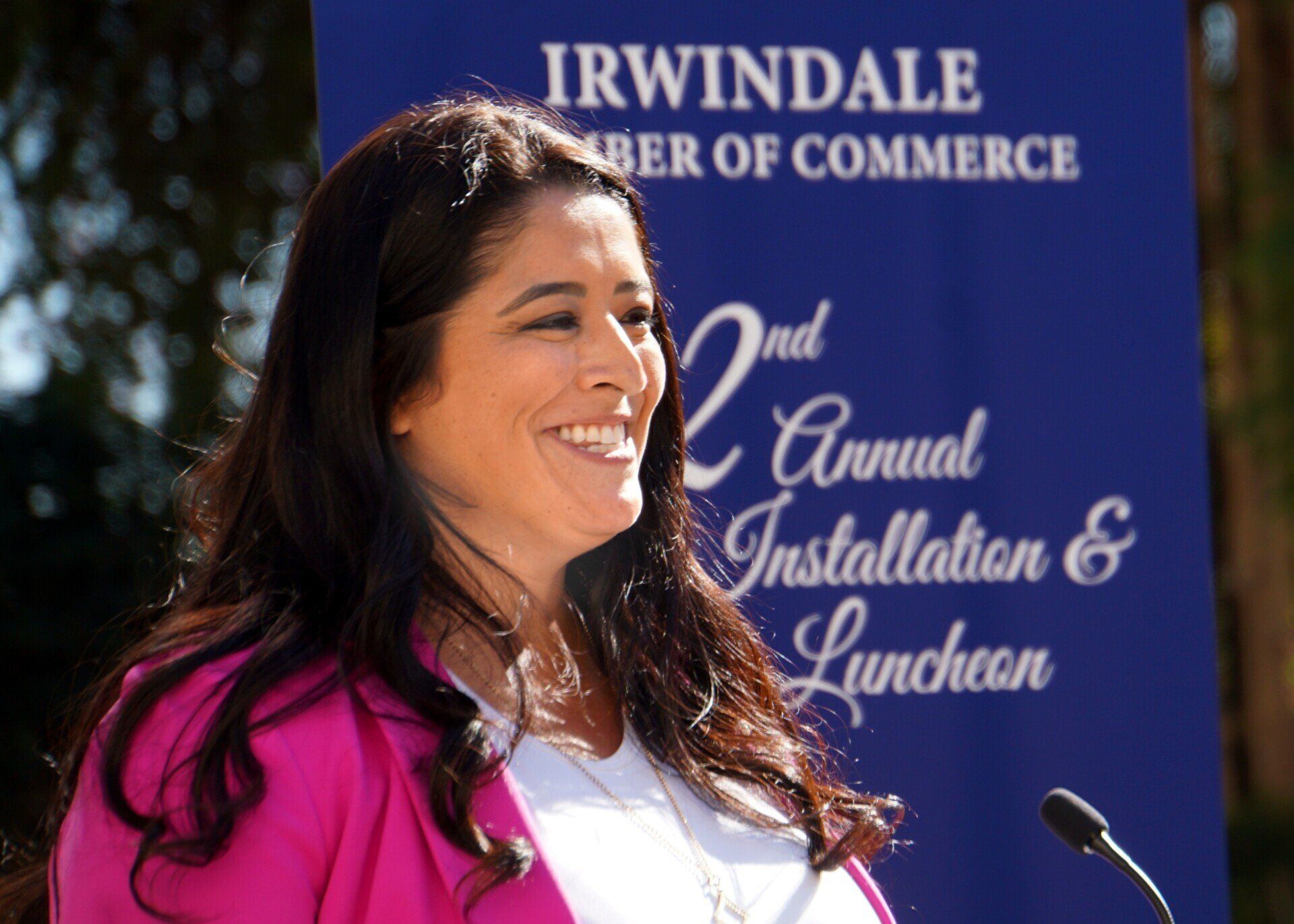 A woman stands in front of a sign that says irwindale member of commerce