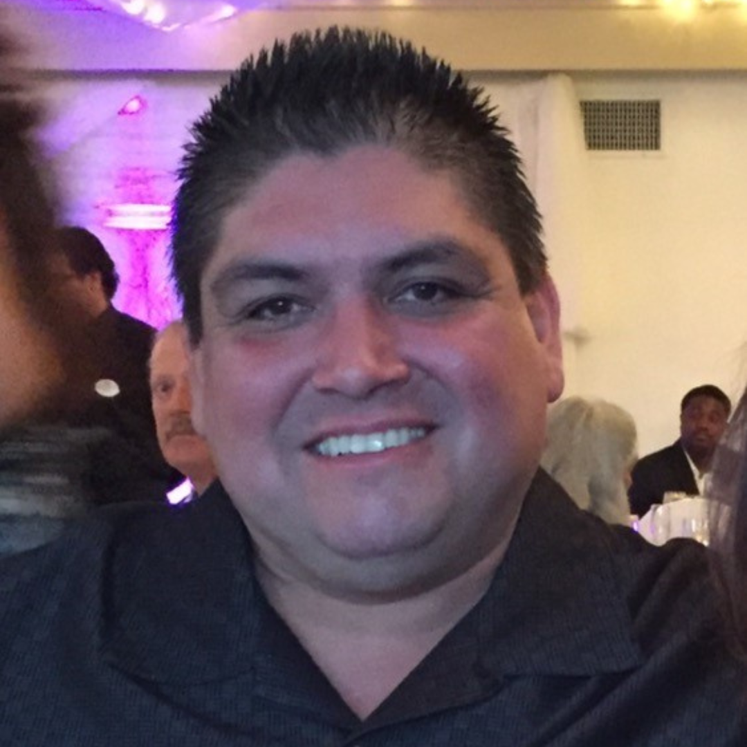 A man in a black shirt is smiling for the camera