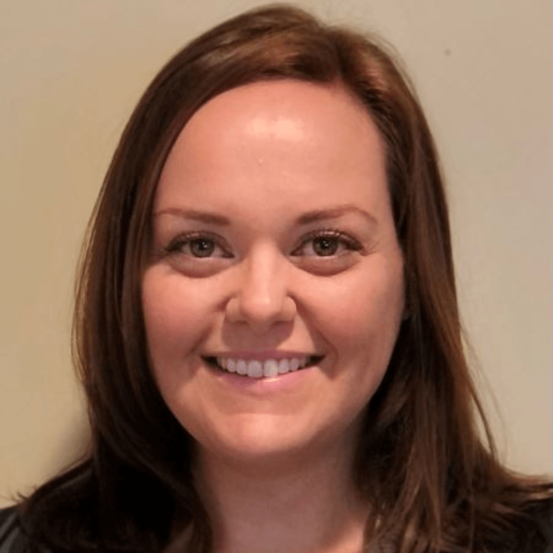 A woman with long brown hair is smiling for the camera