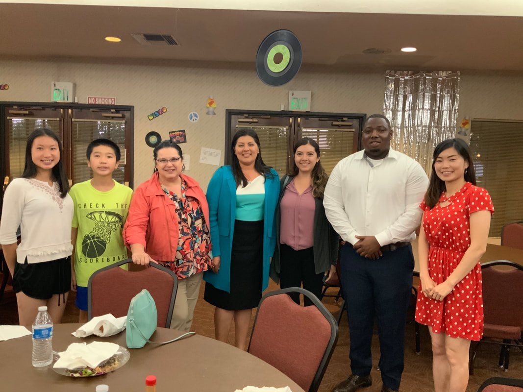 A group of people are posing for a picture in front of a table.