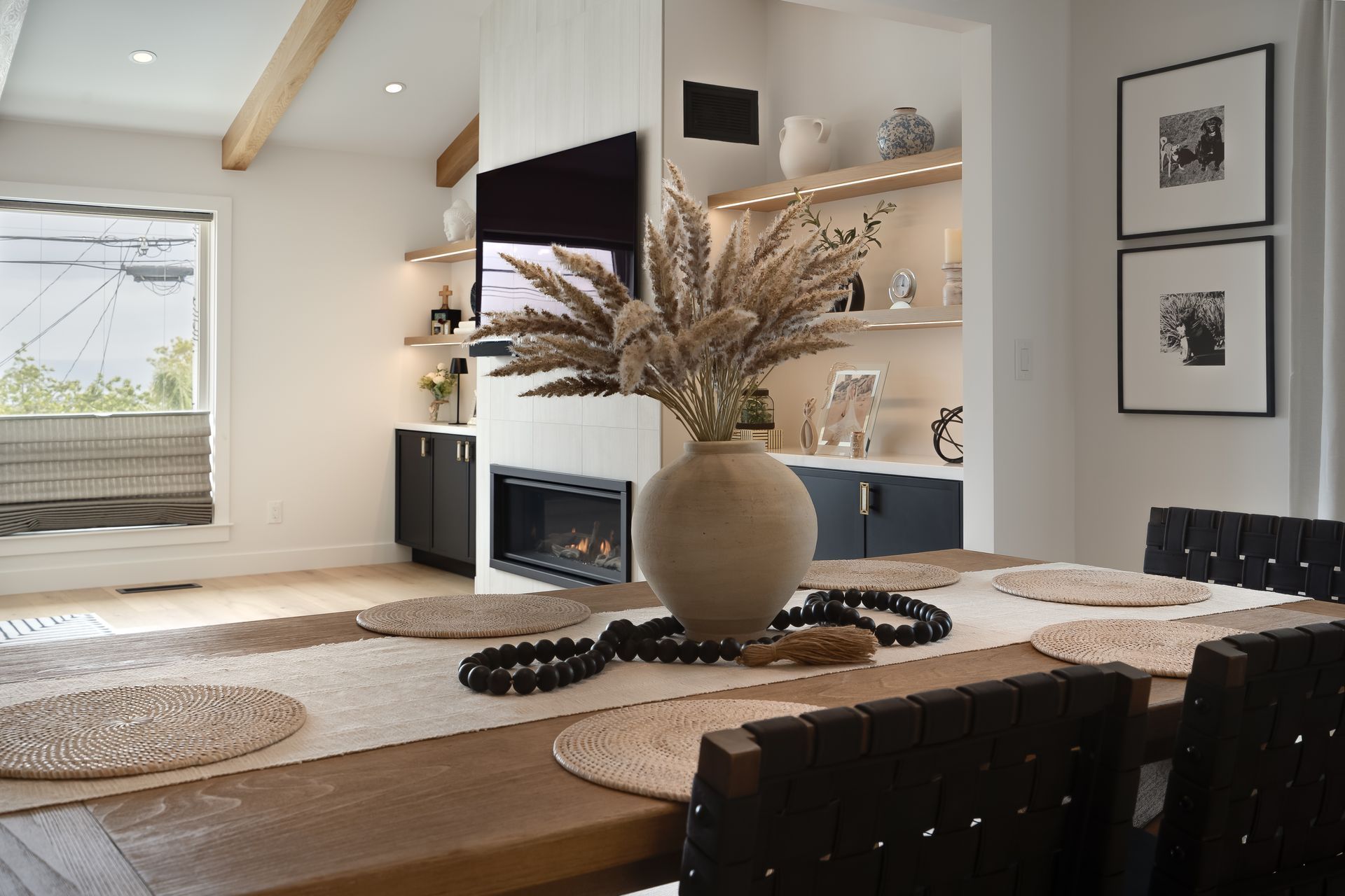 Dining room with a long wooden table set for a meal, a fireplace, and built-in shelves.