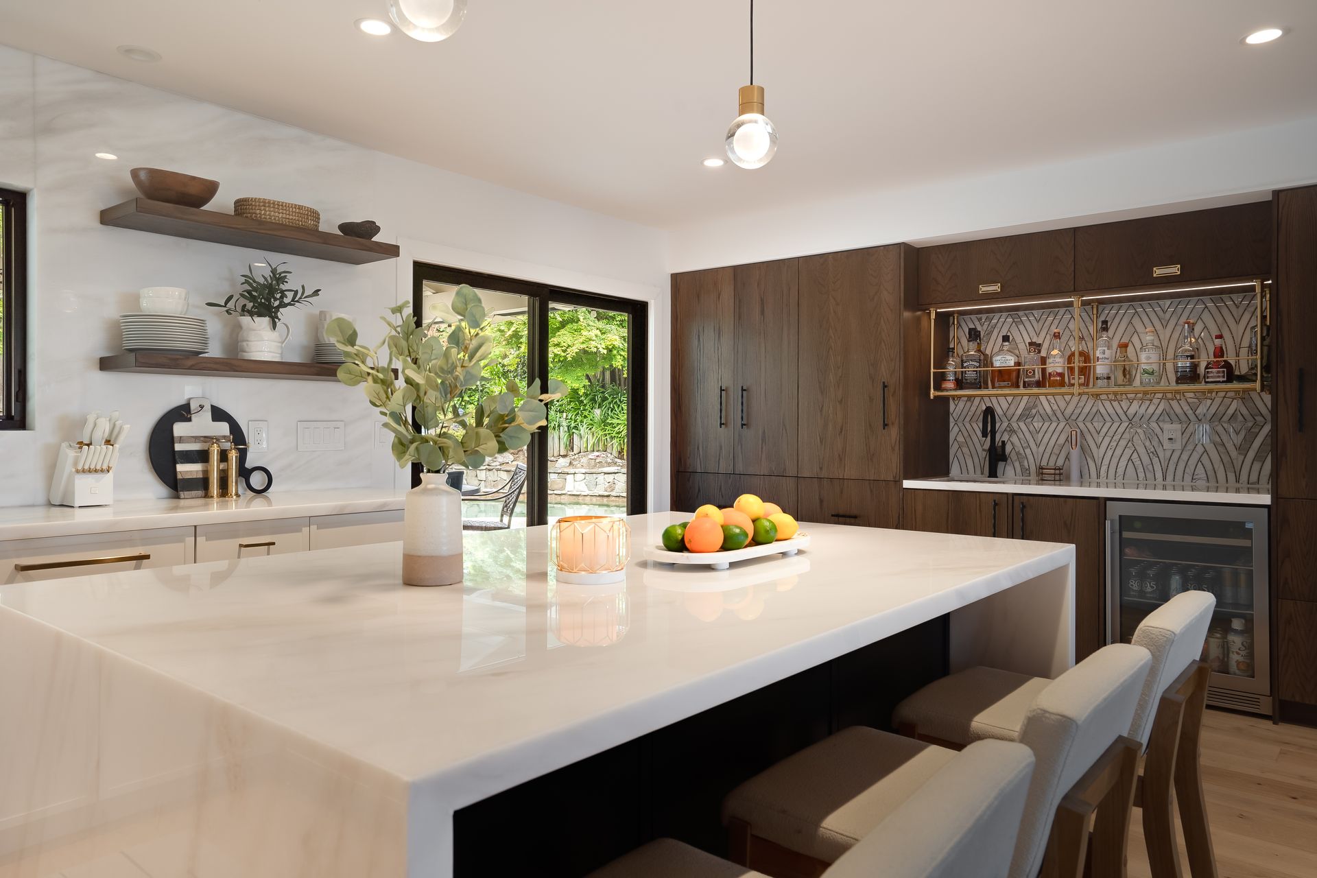 Modern kitchen with white countertop island, wooden cabinets, and bar.