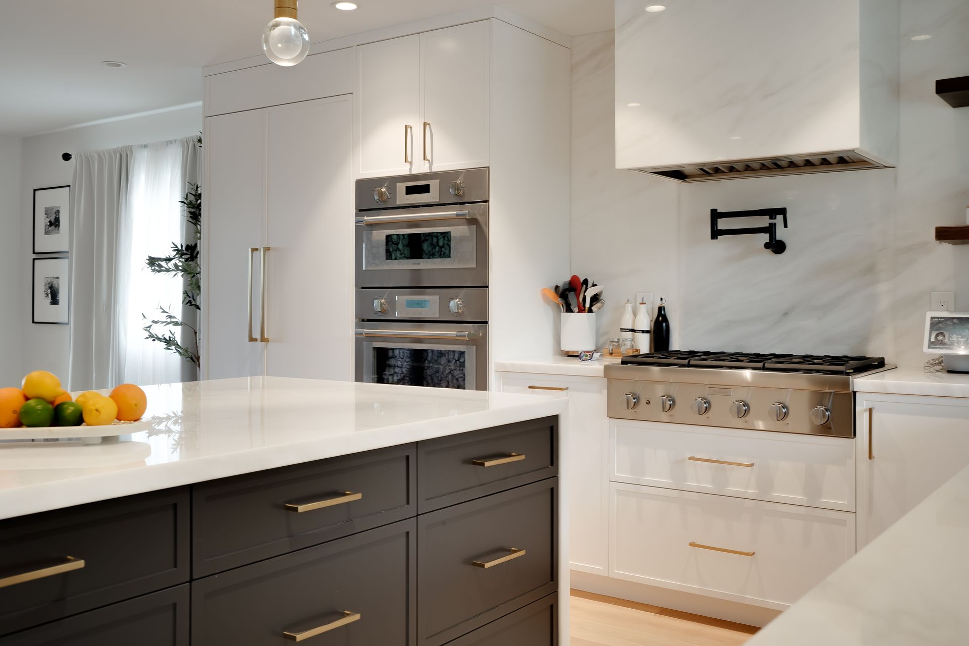 Modern white and gray kitchen with island and stainless steel appliances.