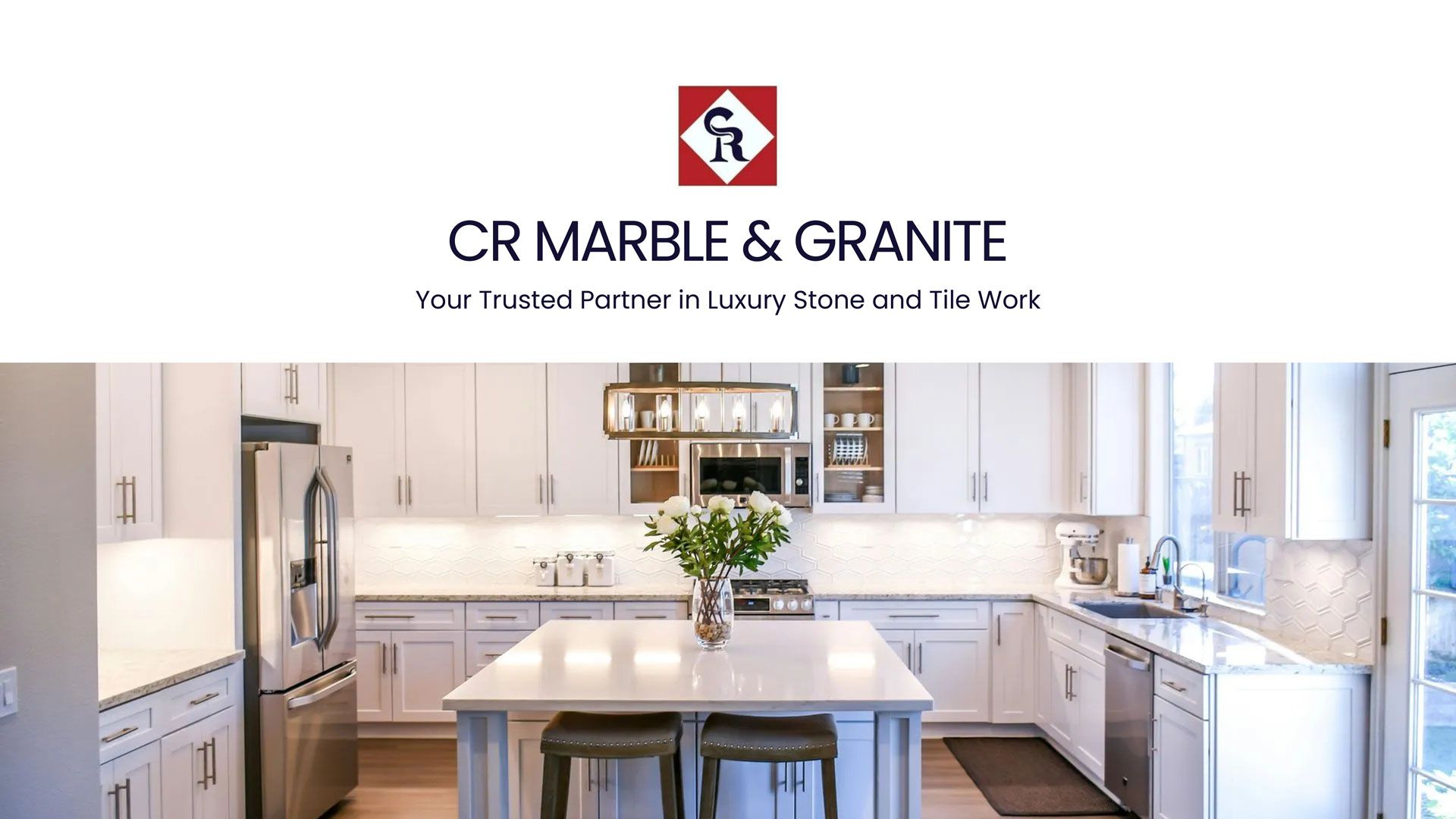 CR Marble & Granite logo with a kitchen featuring white cabinets, marble countertops, and a central island.