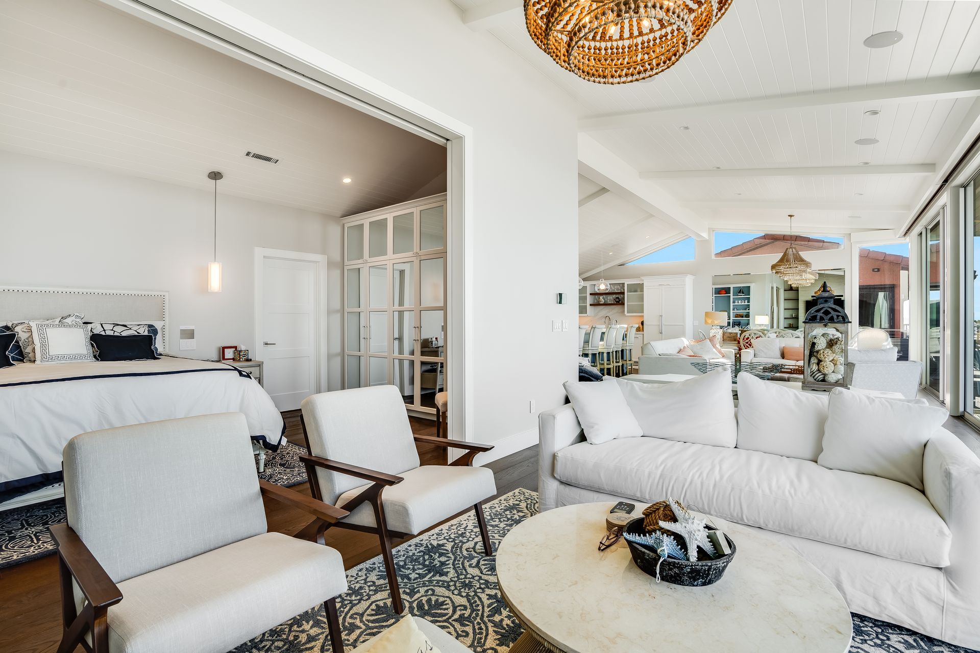 Bright interior with bedroom, seating area, and an open outdoor living space.