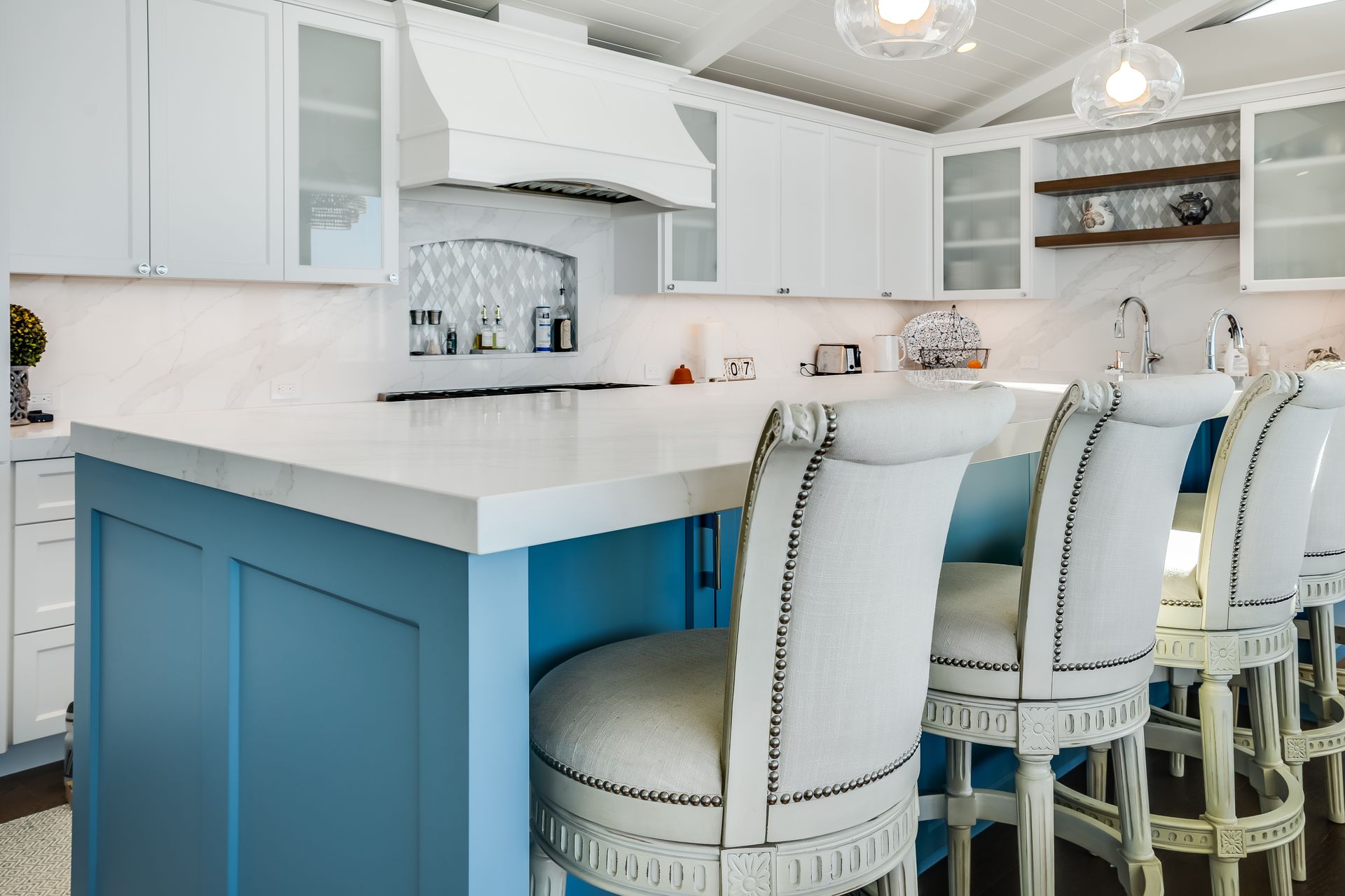 Blue and white kitchen with bar stools.