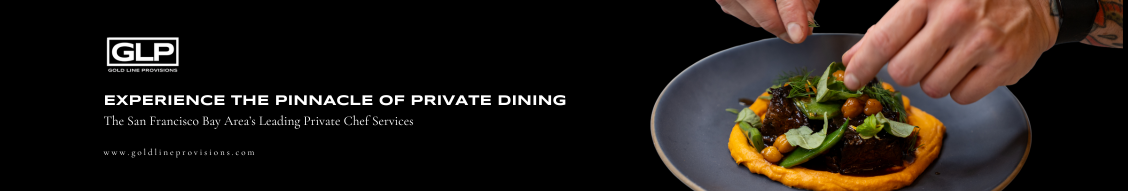 A chef garnishes a plate of food with herbs. Dark plate with yellow base, black background.